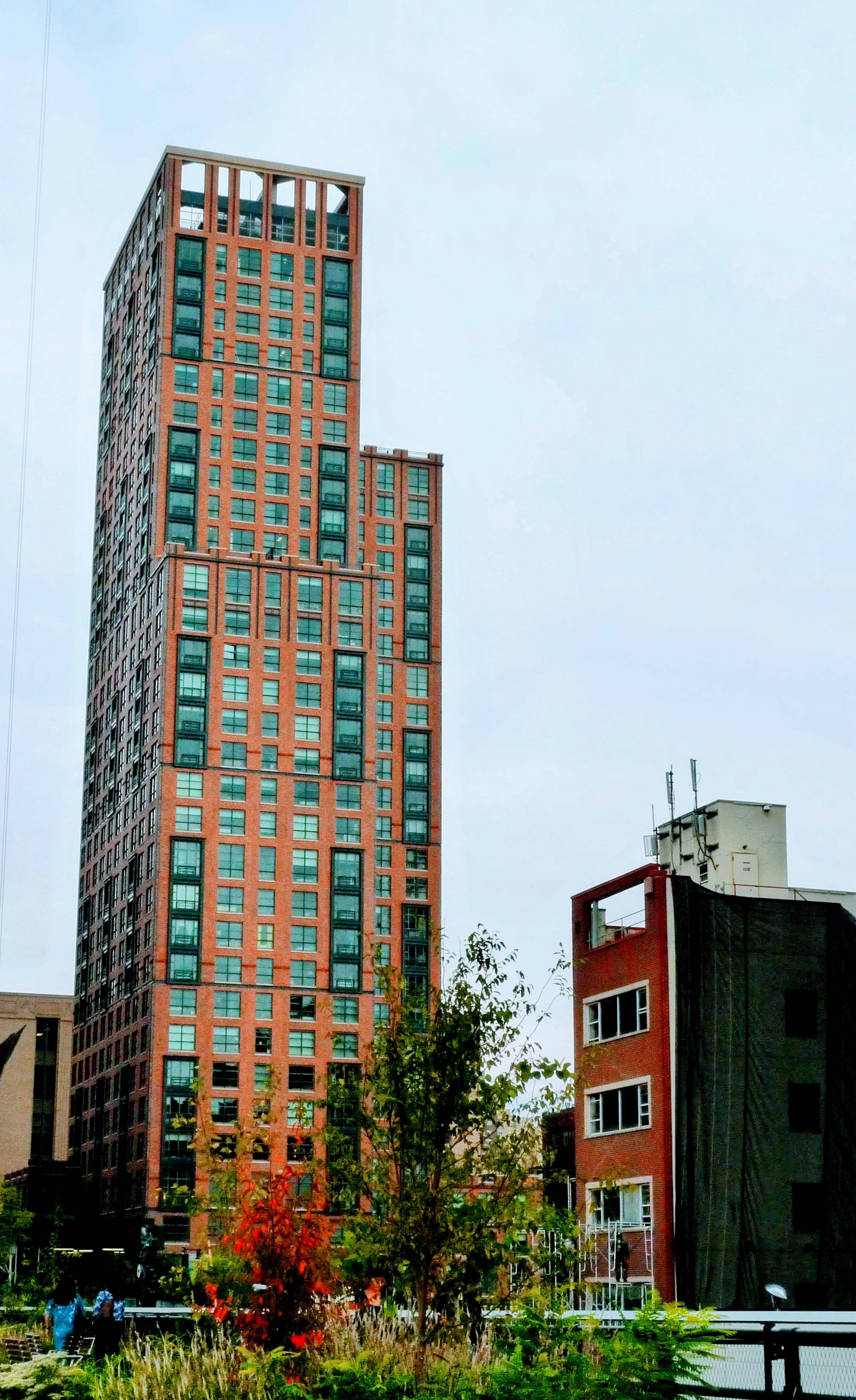 Vue d'un grand bâtiment avec une architecture moderne entouré de structures plus petites et de verdure