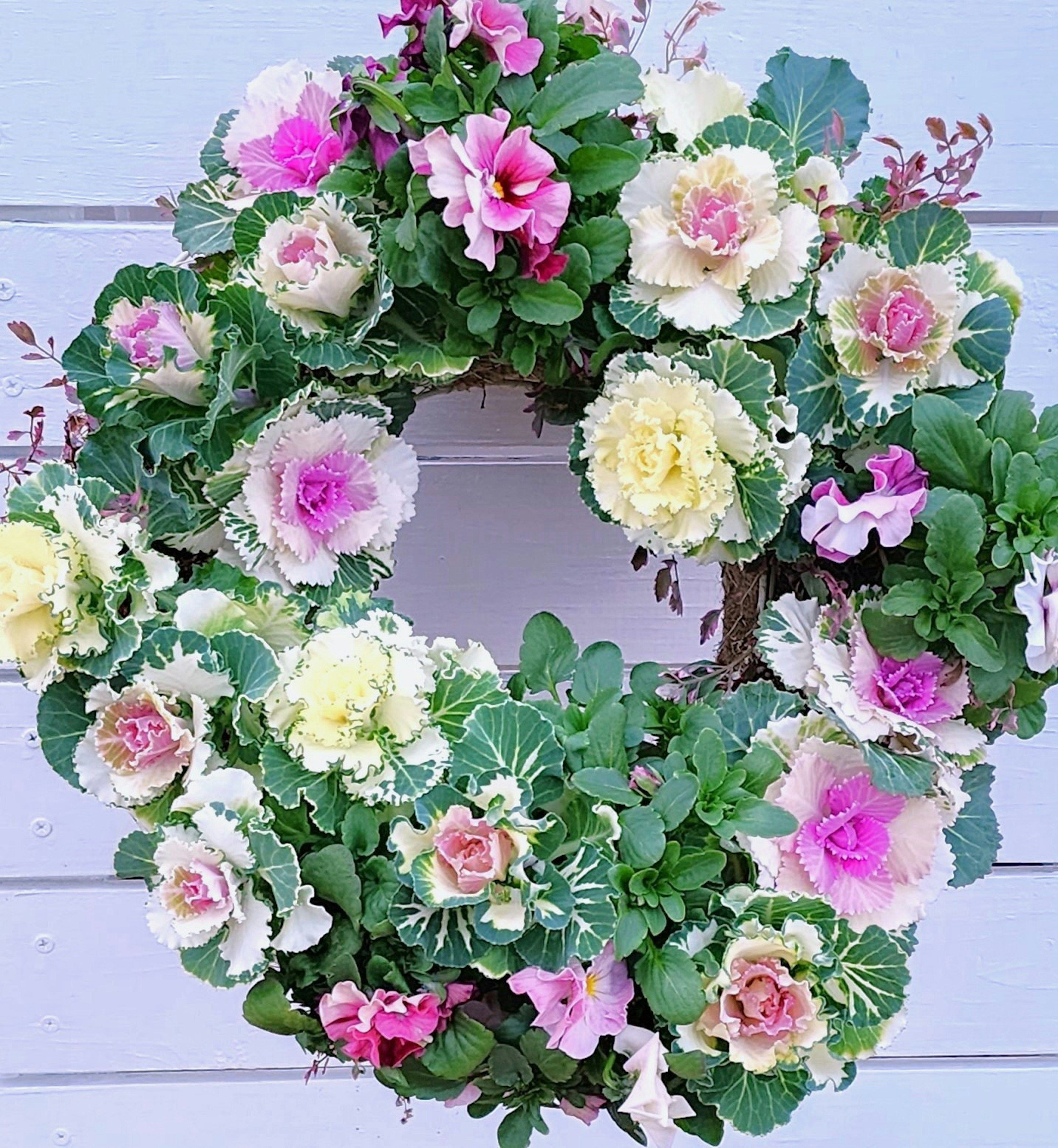 Colorful floral wreath featuring pink and cream flowers with greenery