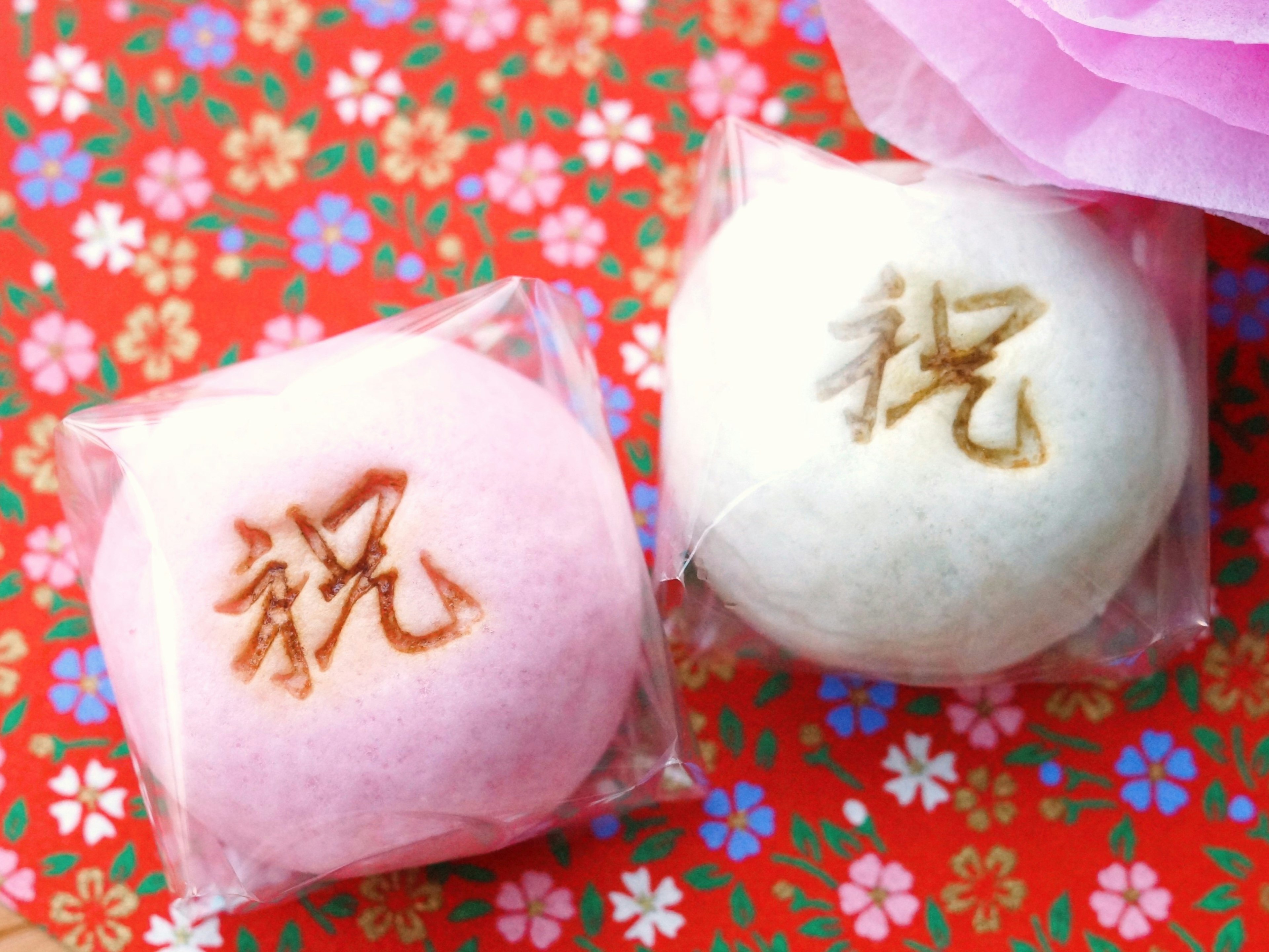 Pink and white rice cakes placed on a floral patterned background