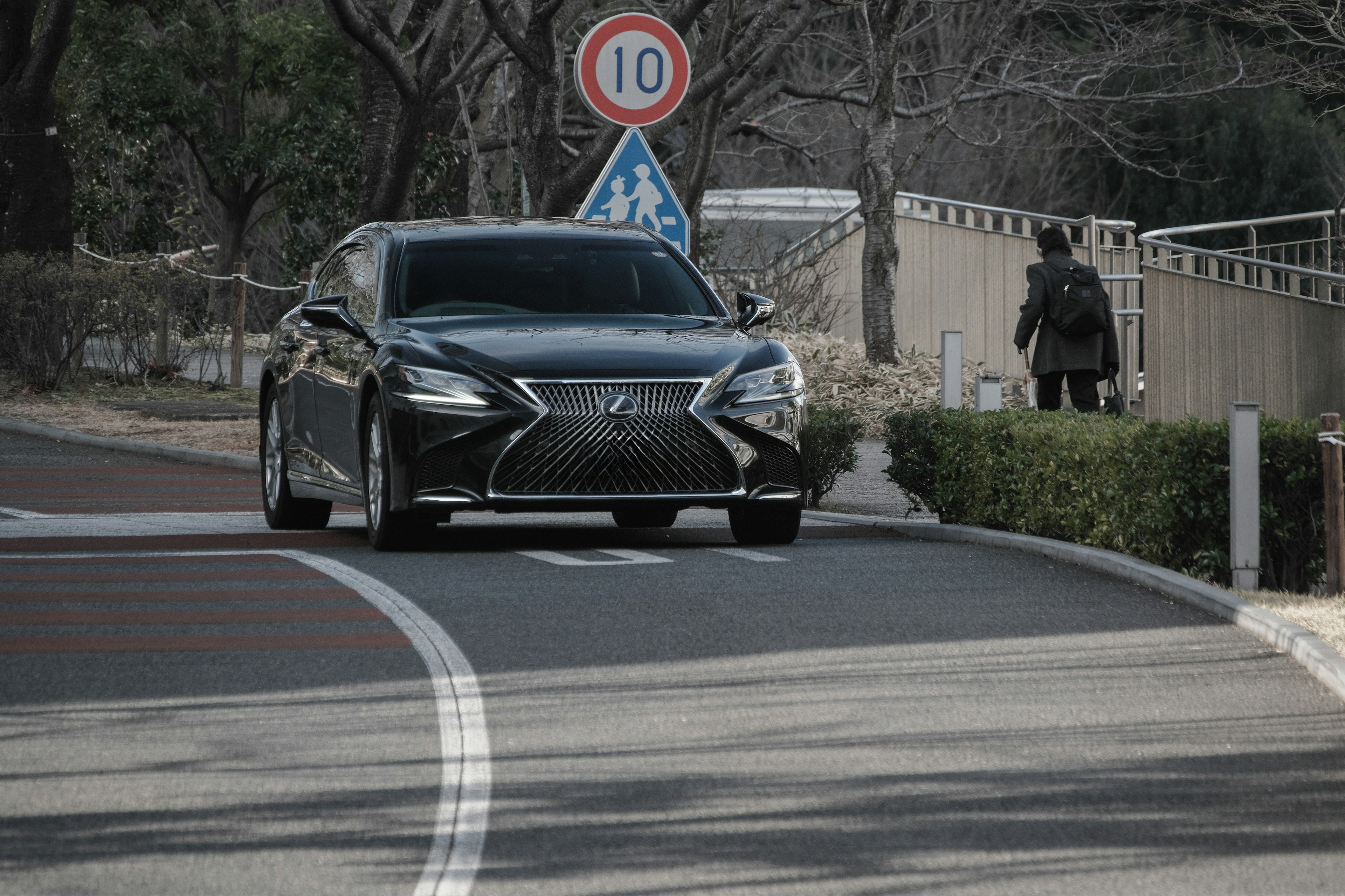 Voiture de luxe noire tournant sur une route de la ville