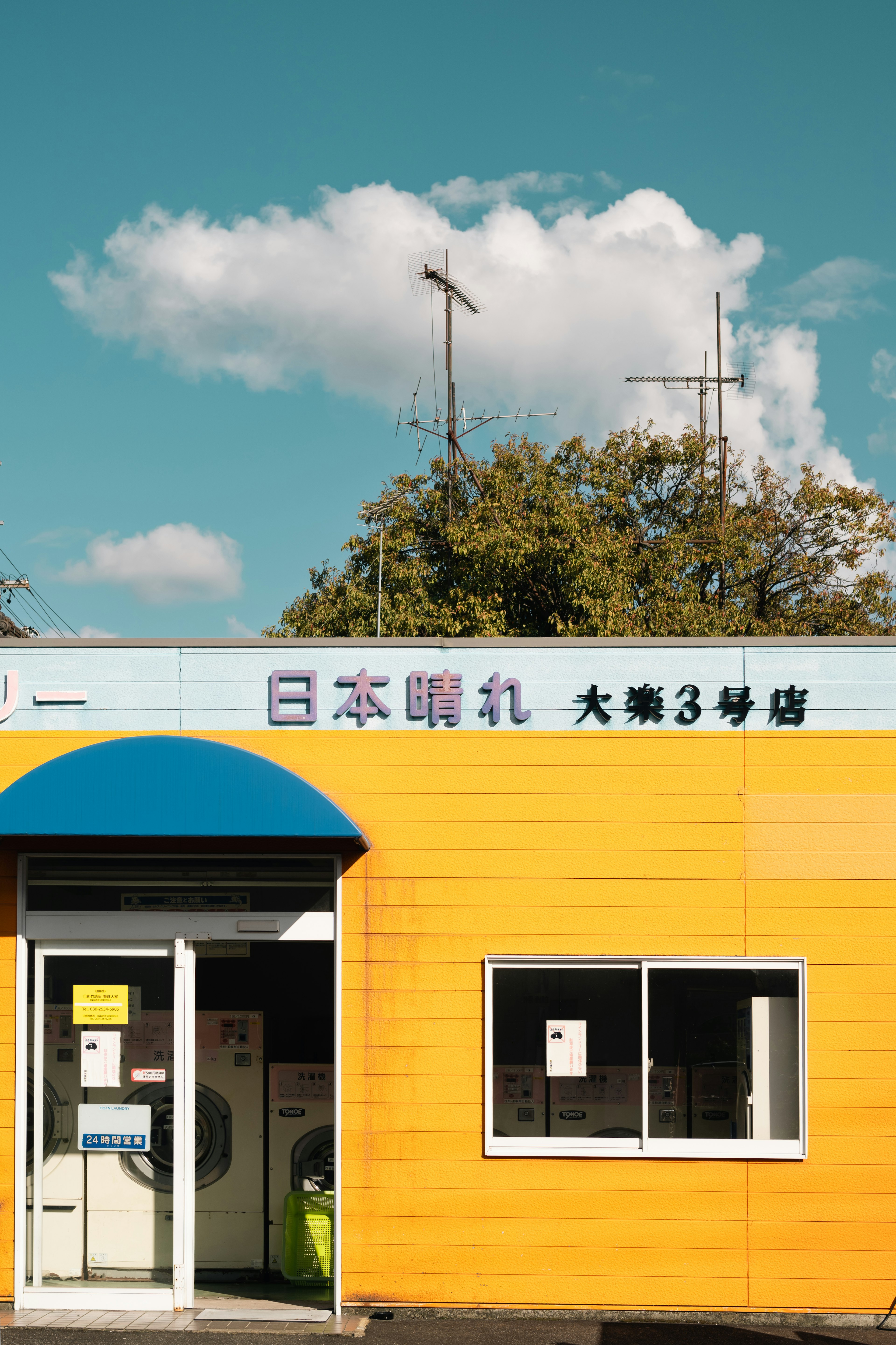 Japanisches Restaurant mit gelber Fassade und blauer Markise