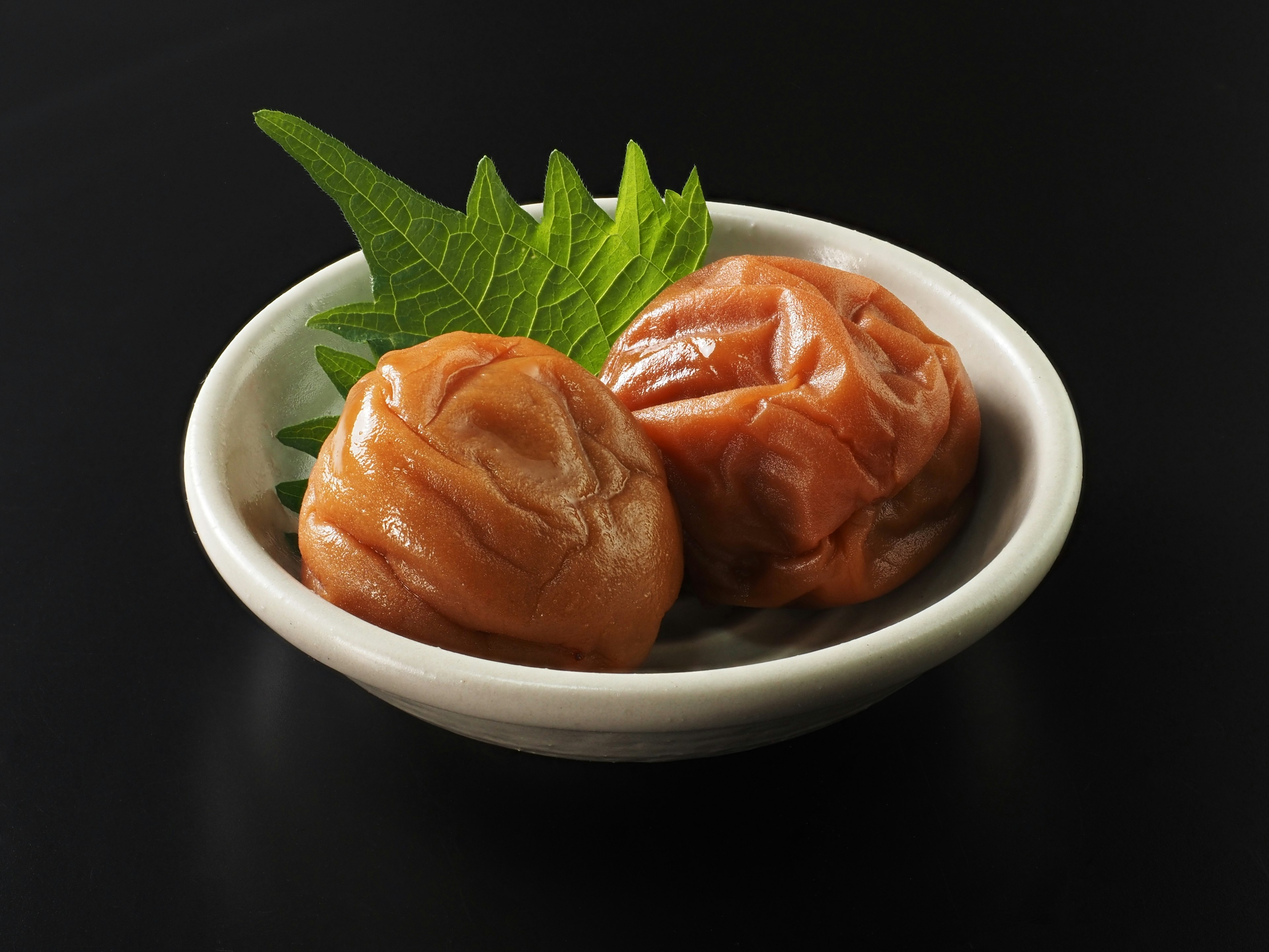 Pickled plums with shiso leaves in a small dish