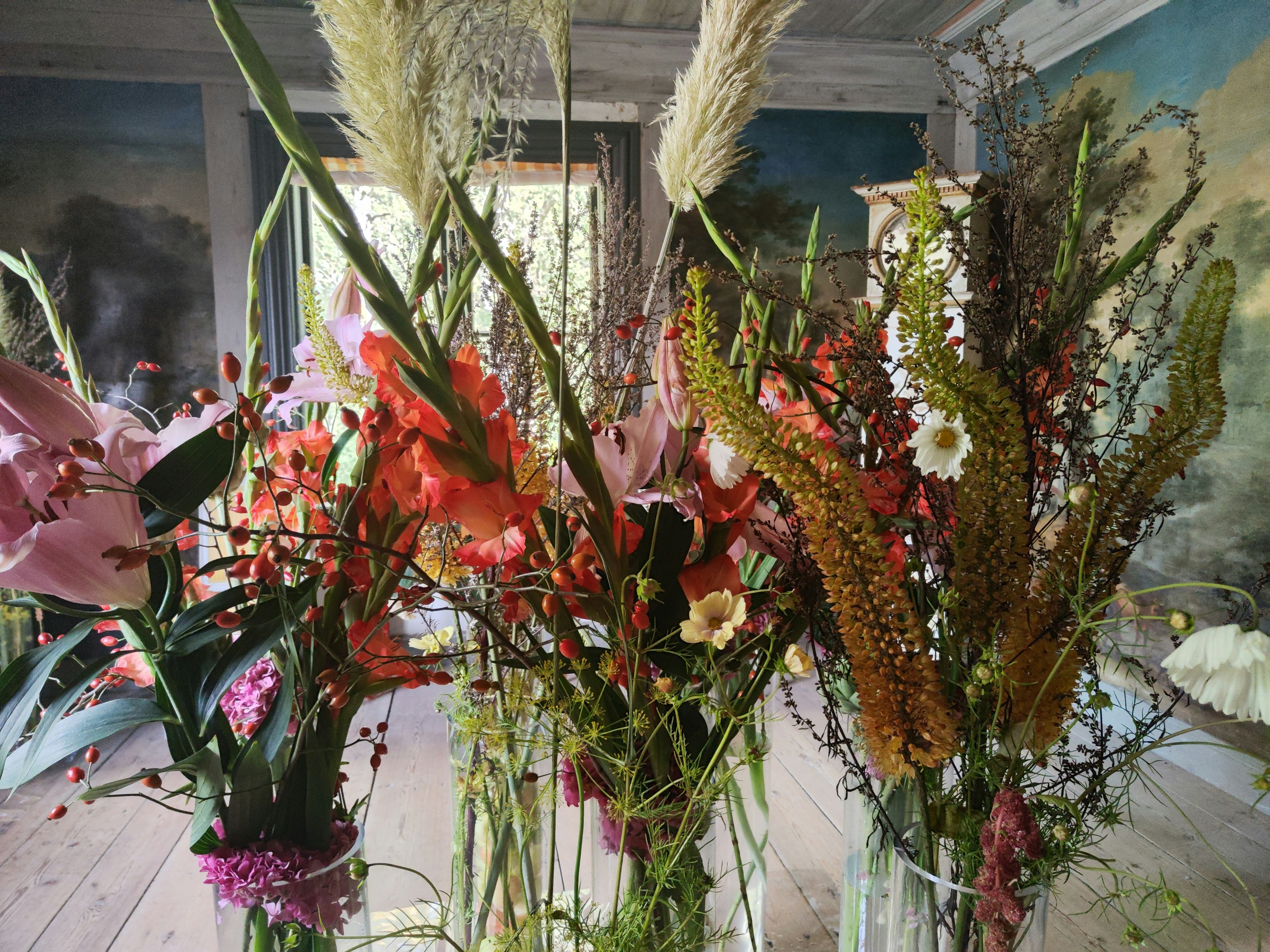 Indoor scene featuring a variety of colorful flowers in vases