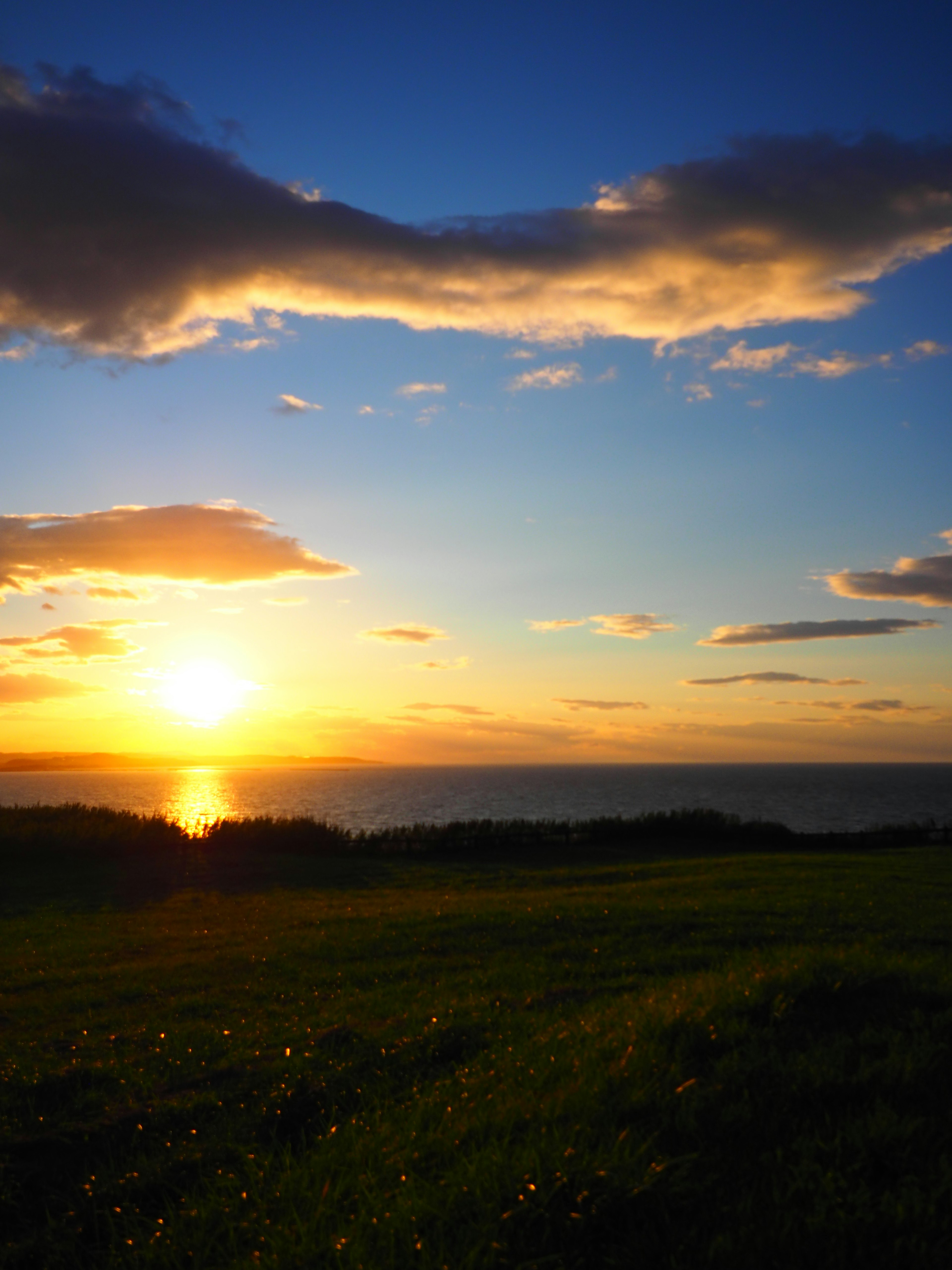 Schöner Sonnenuntergang über dem Ozean mit blauem Himmel und Wolken