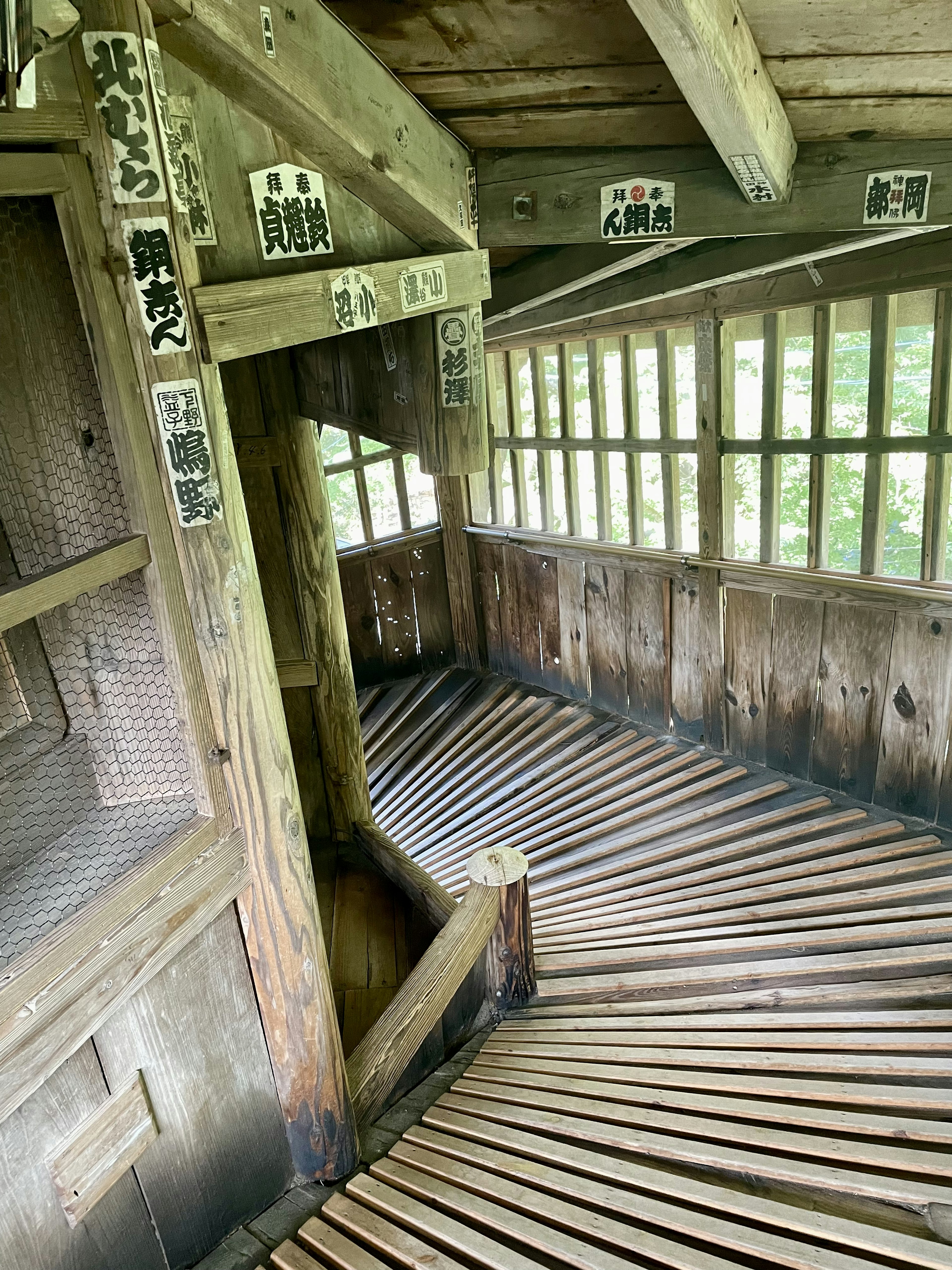 Interior of a winding wooden corridor with stairs and windows