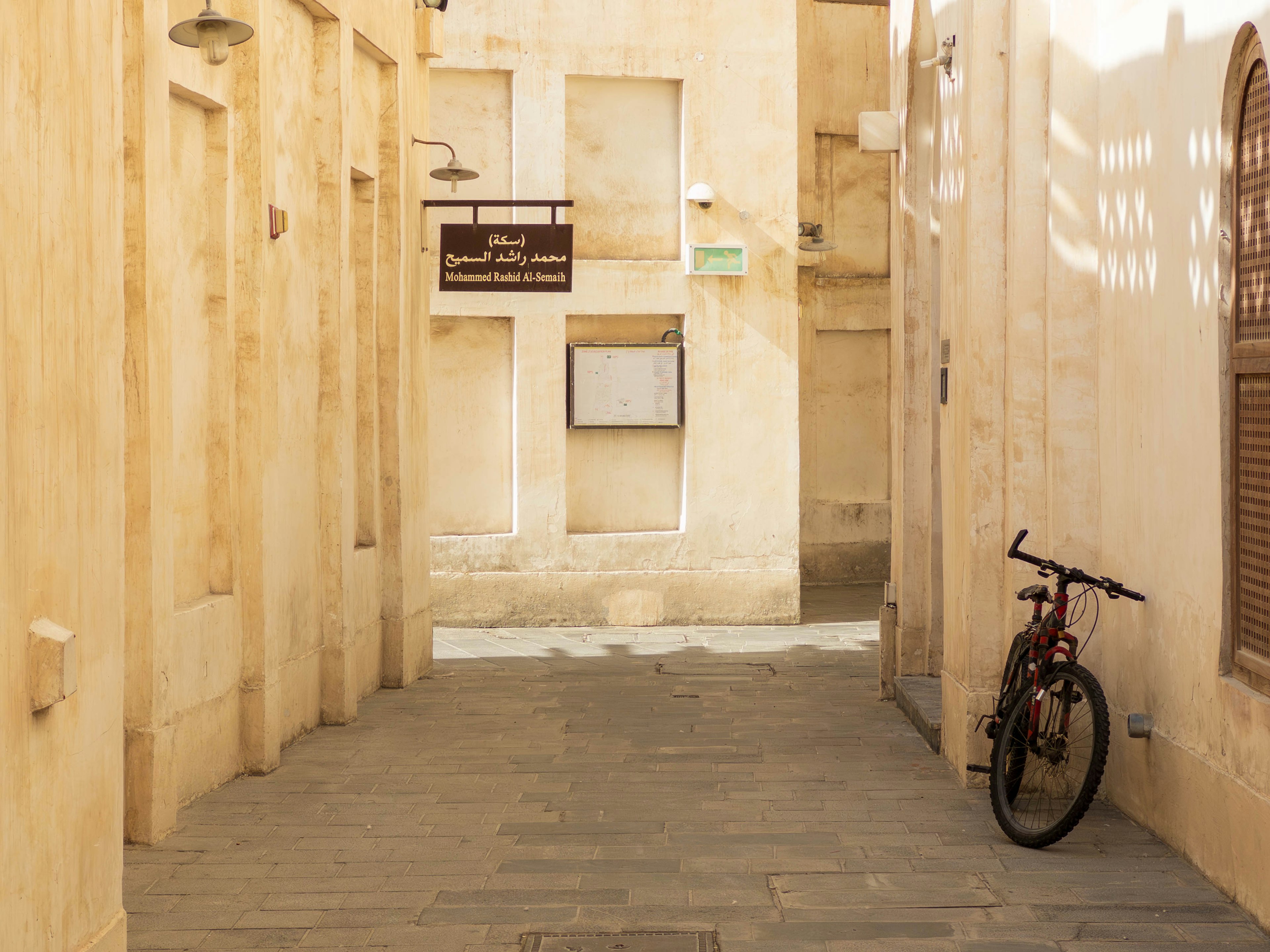 Vicolo stretto con una bicicletta parcheggiata e edifici di colore chiaro