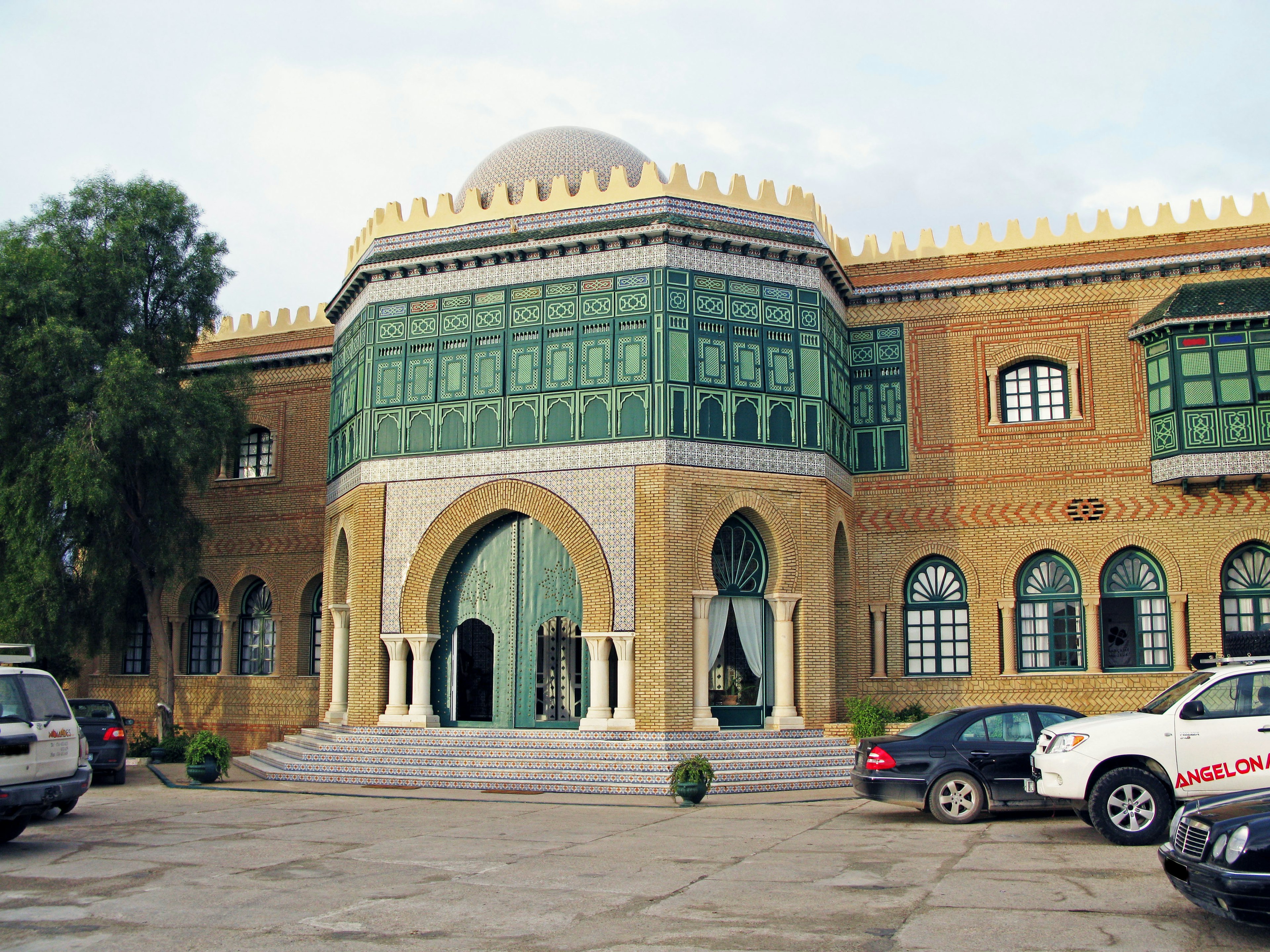 Architektonische Fassade mit kunstvollen Dekorationen großer bogenförmiger Eingang und grünen Fenstern