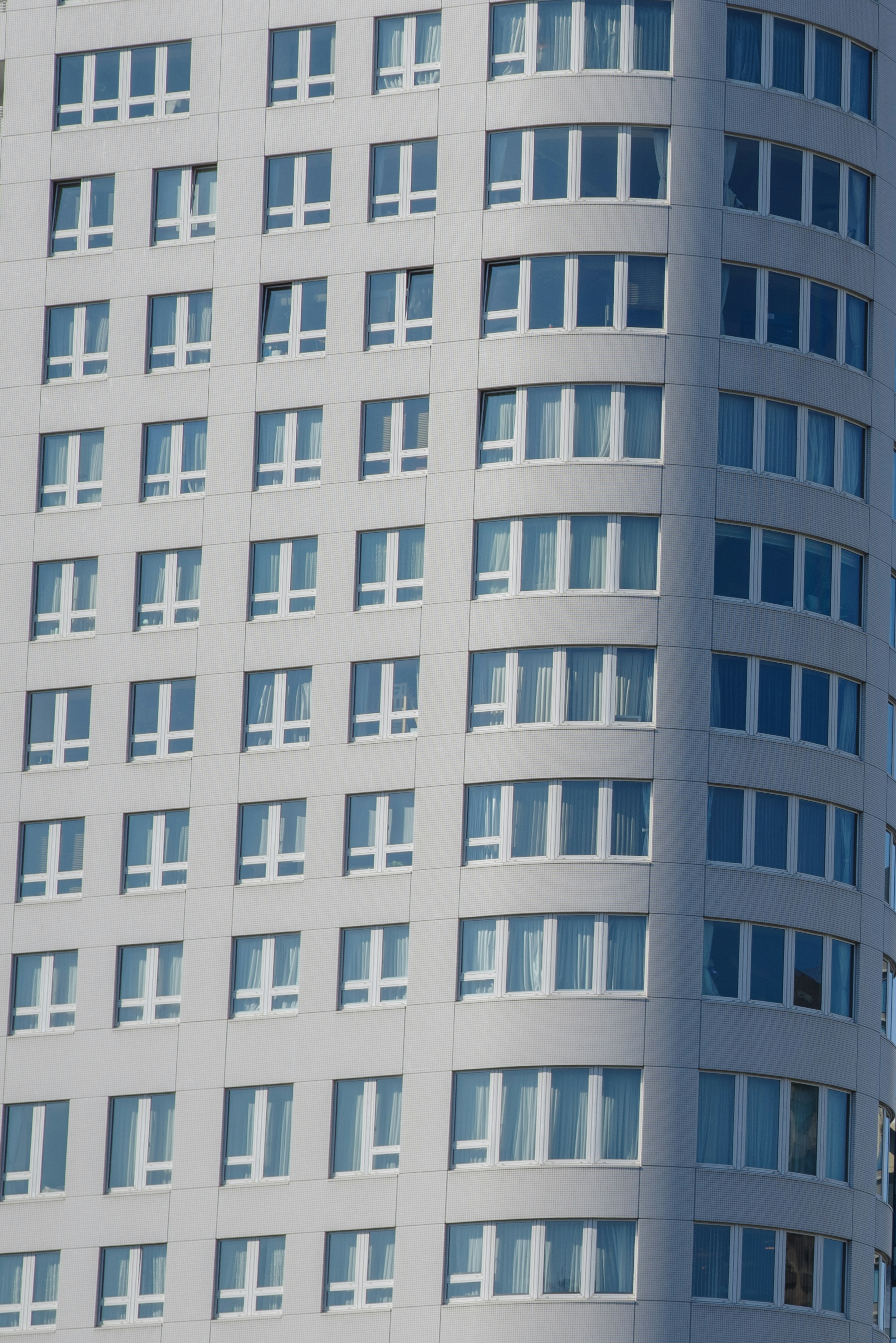 Gebäude mit gebogener Fassade und blauen Fenstern