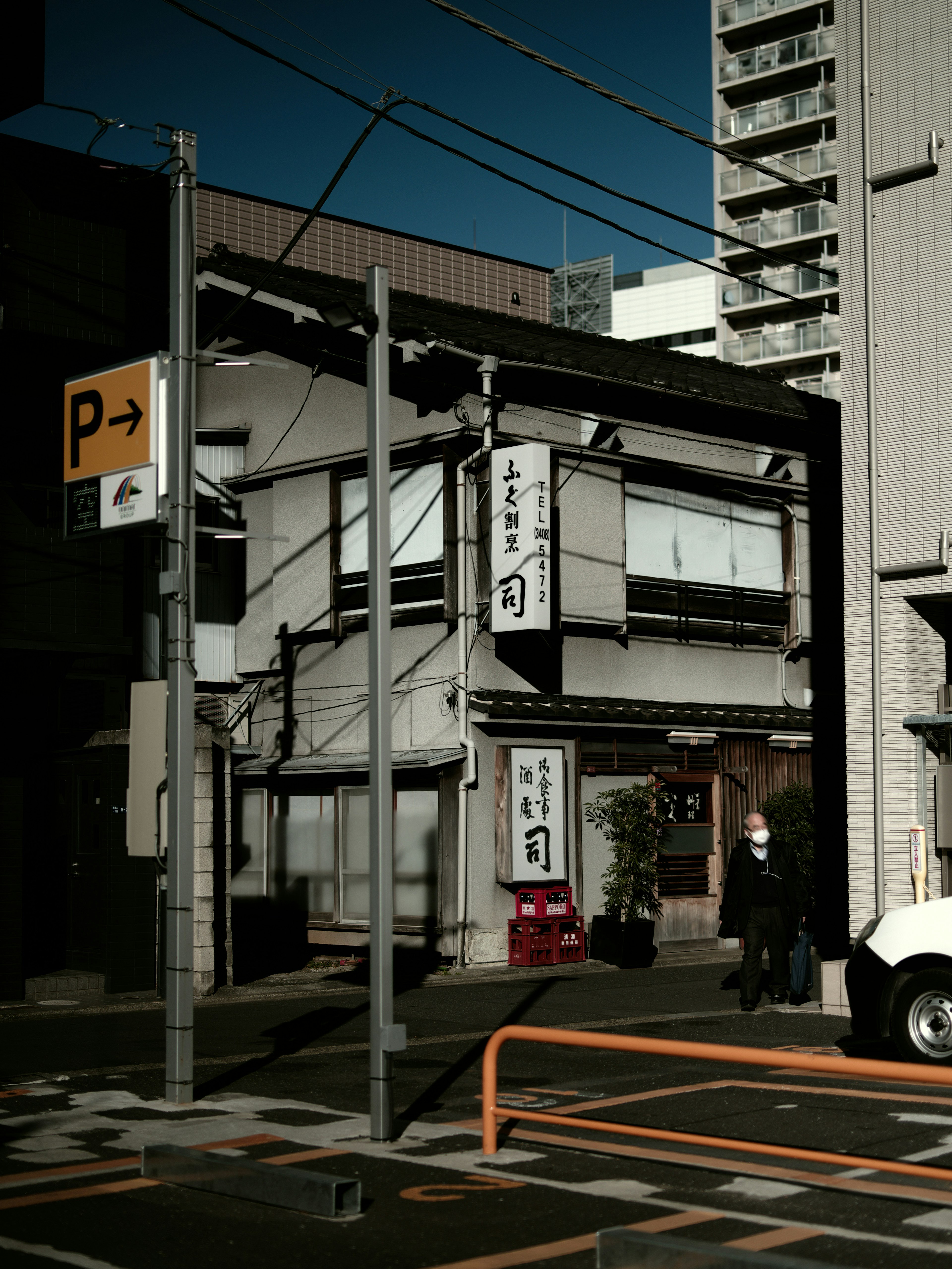 Charmante Straßenecke mit einem traditionellen japanischen Gebäude neben modernen Hochhäusern