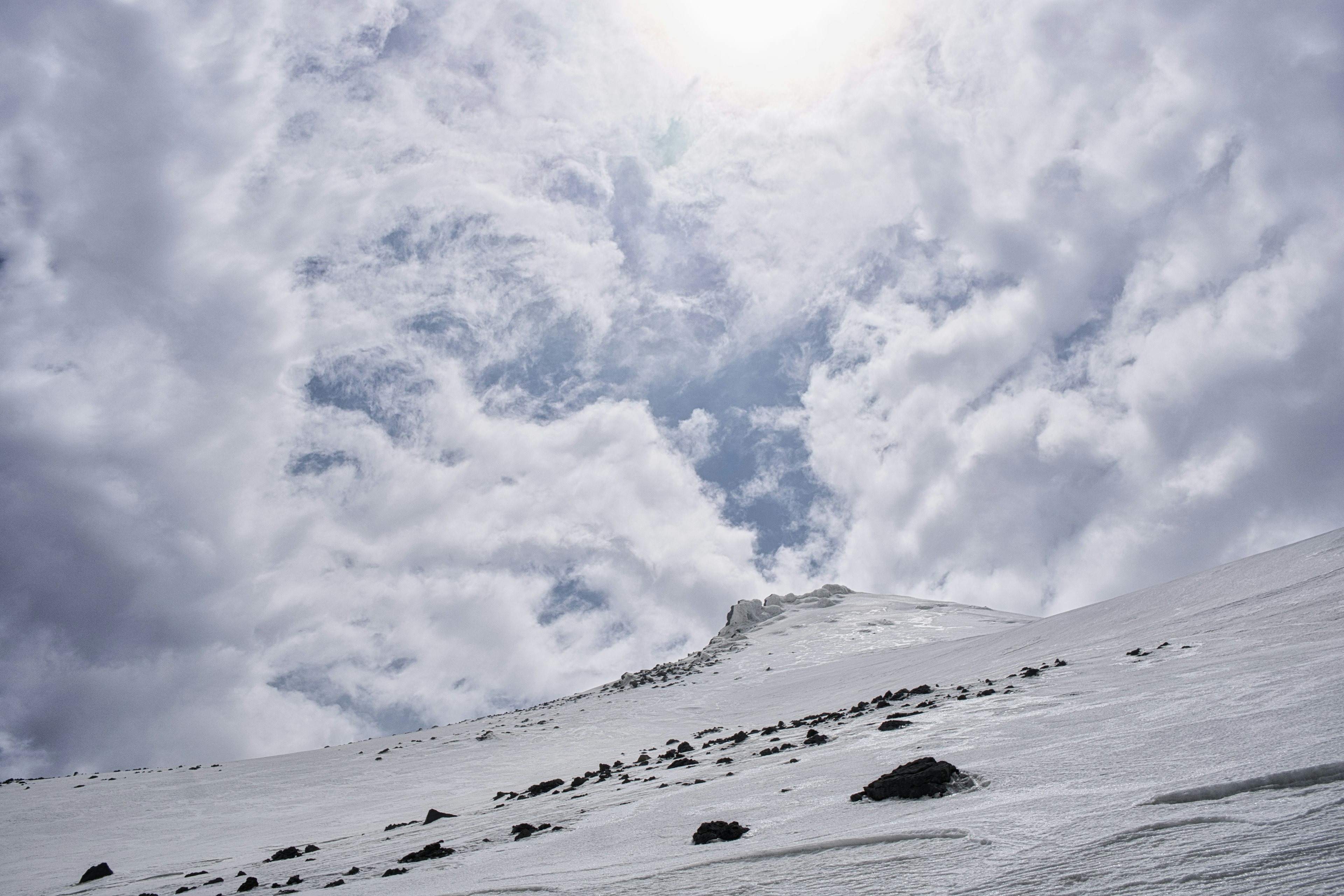 Pente de montagne enneigée avec un ciel nuageux