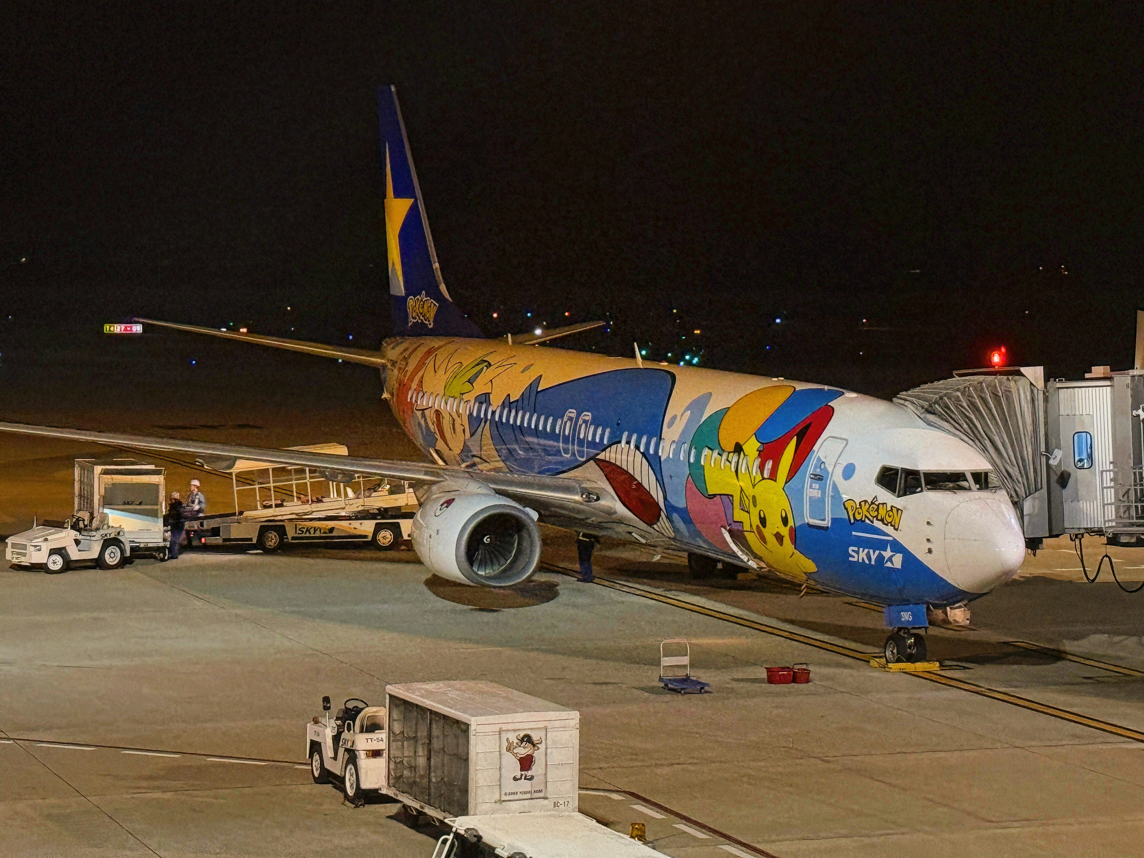 Avión colorido estacionado en el aeropuerto por la noche