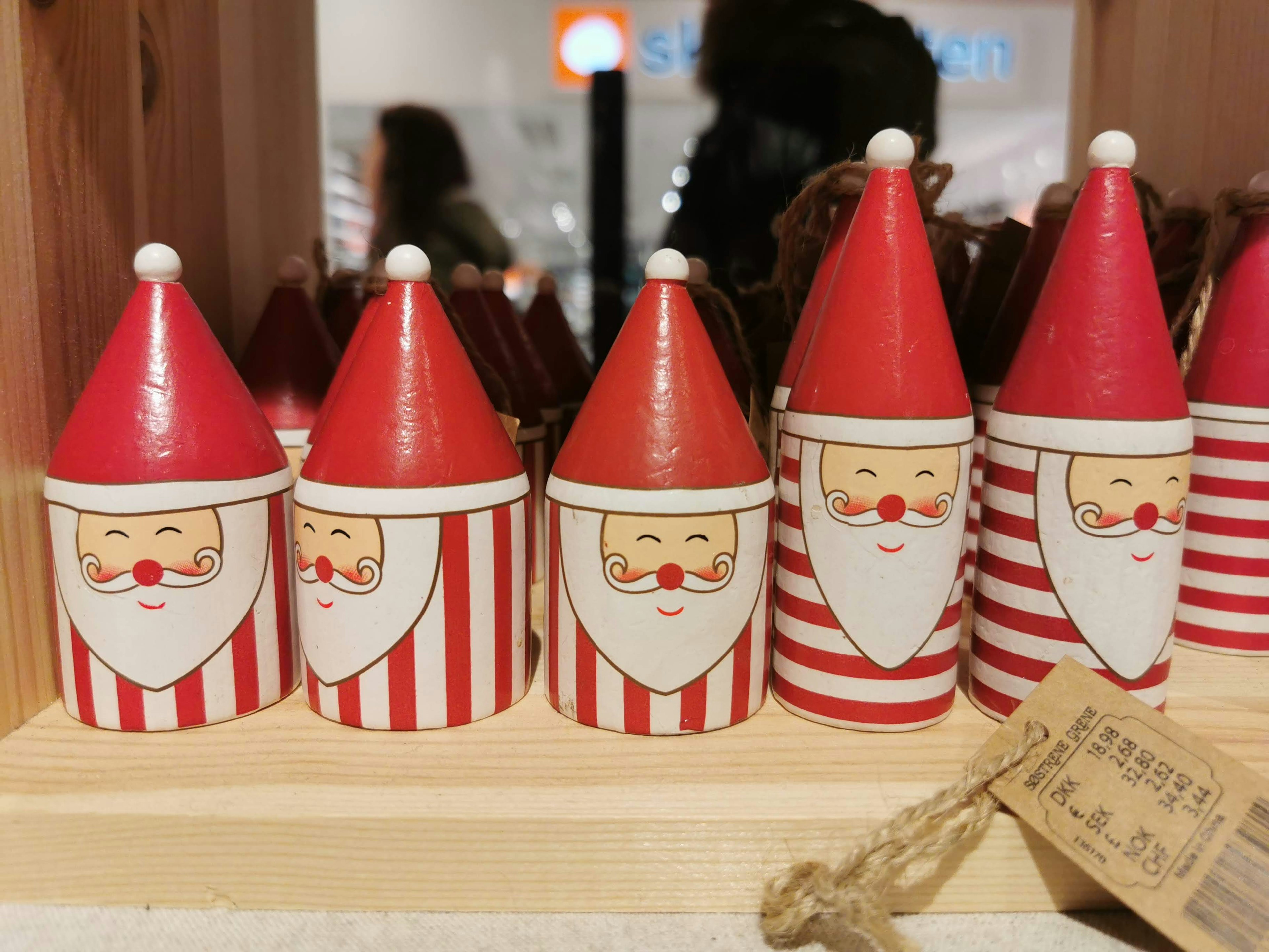 Exhibición de decoraciones de madera con personajes de Santa con sombreros rojos