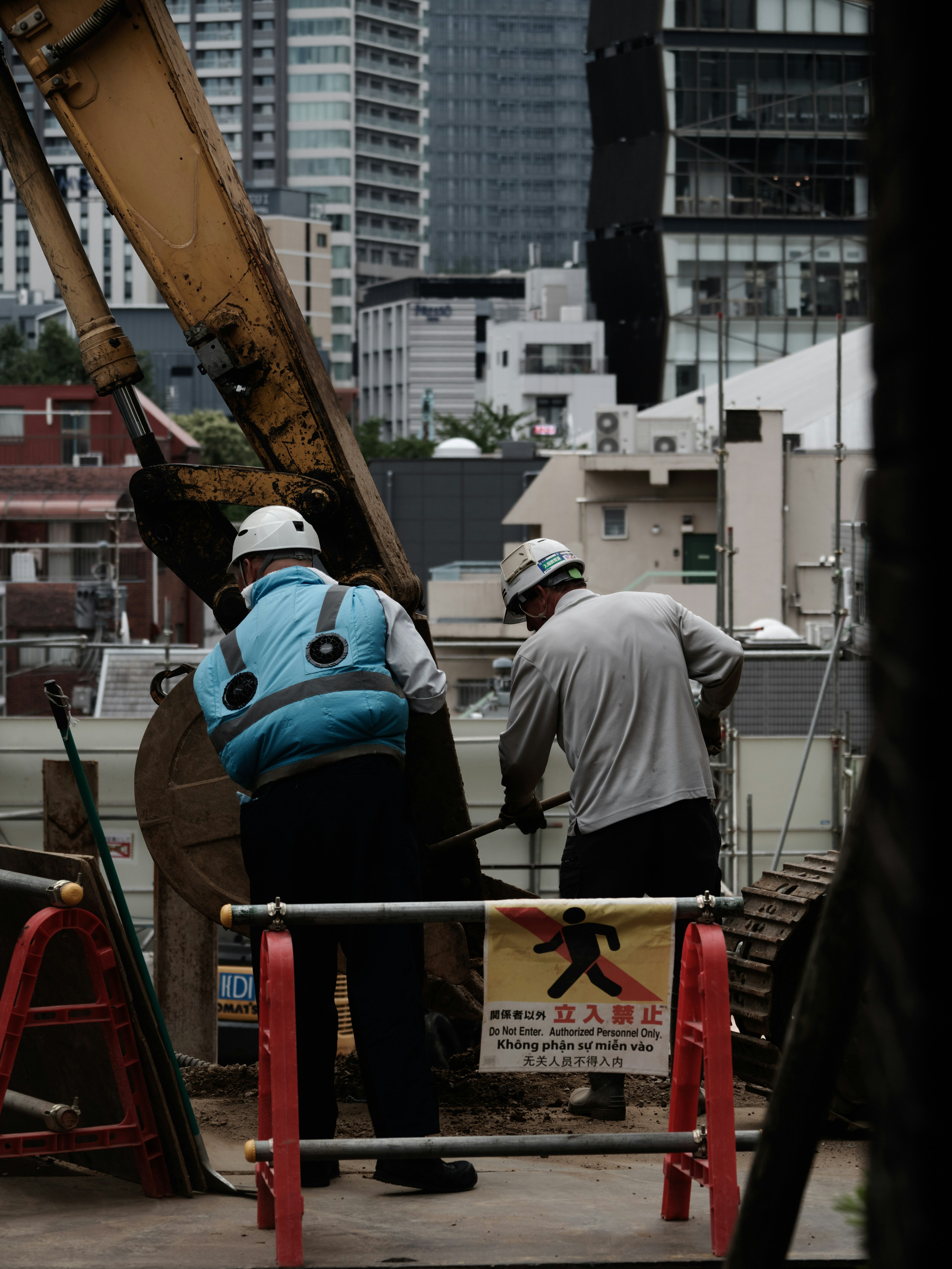 Dos trabajadores de la construcción en un sitio de construcción usando cascos y chalecos de seguridad