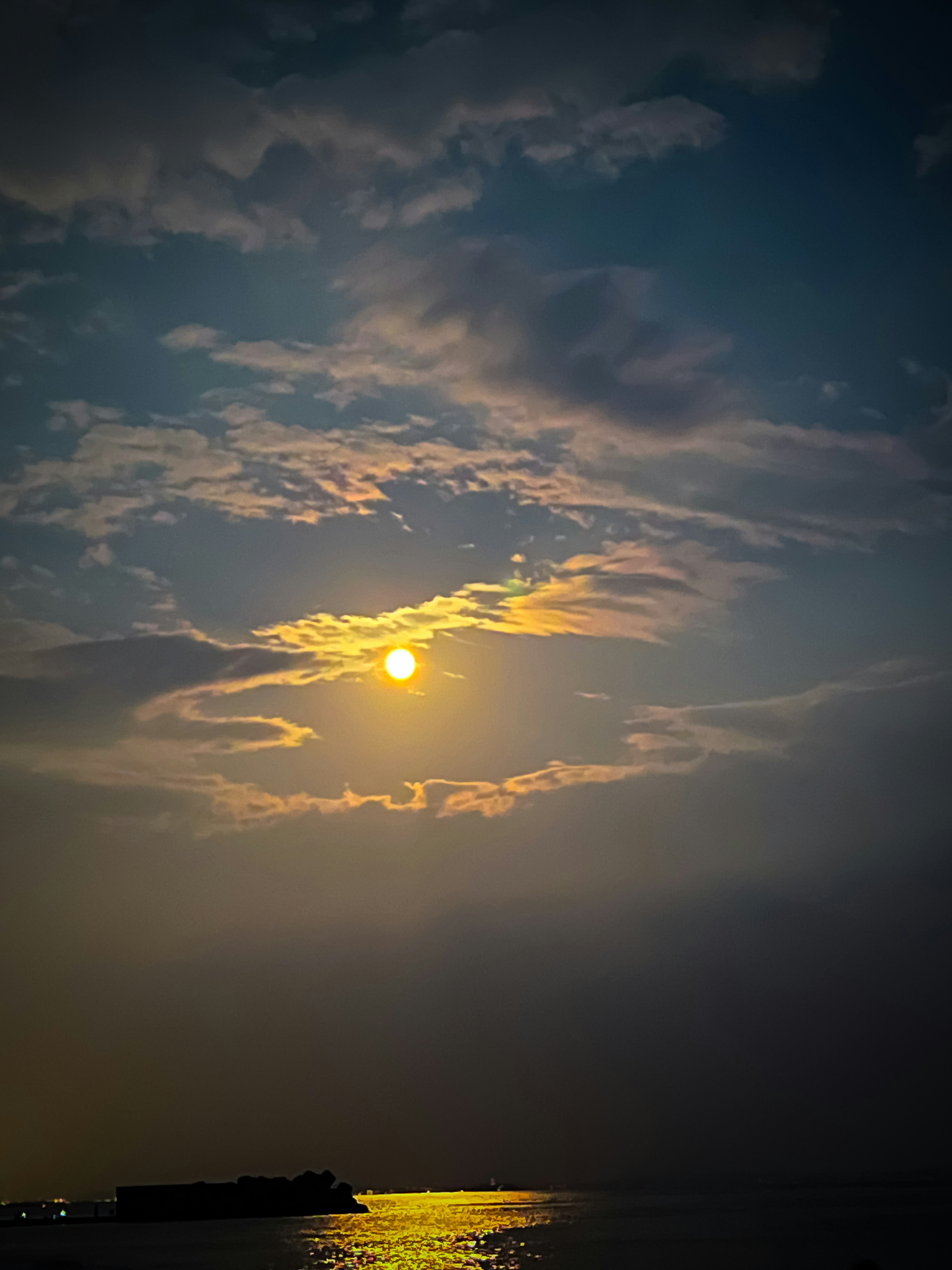 夕日が雲に覆われた海の風景