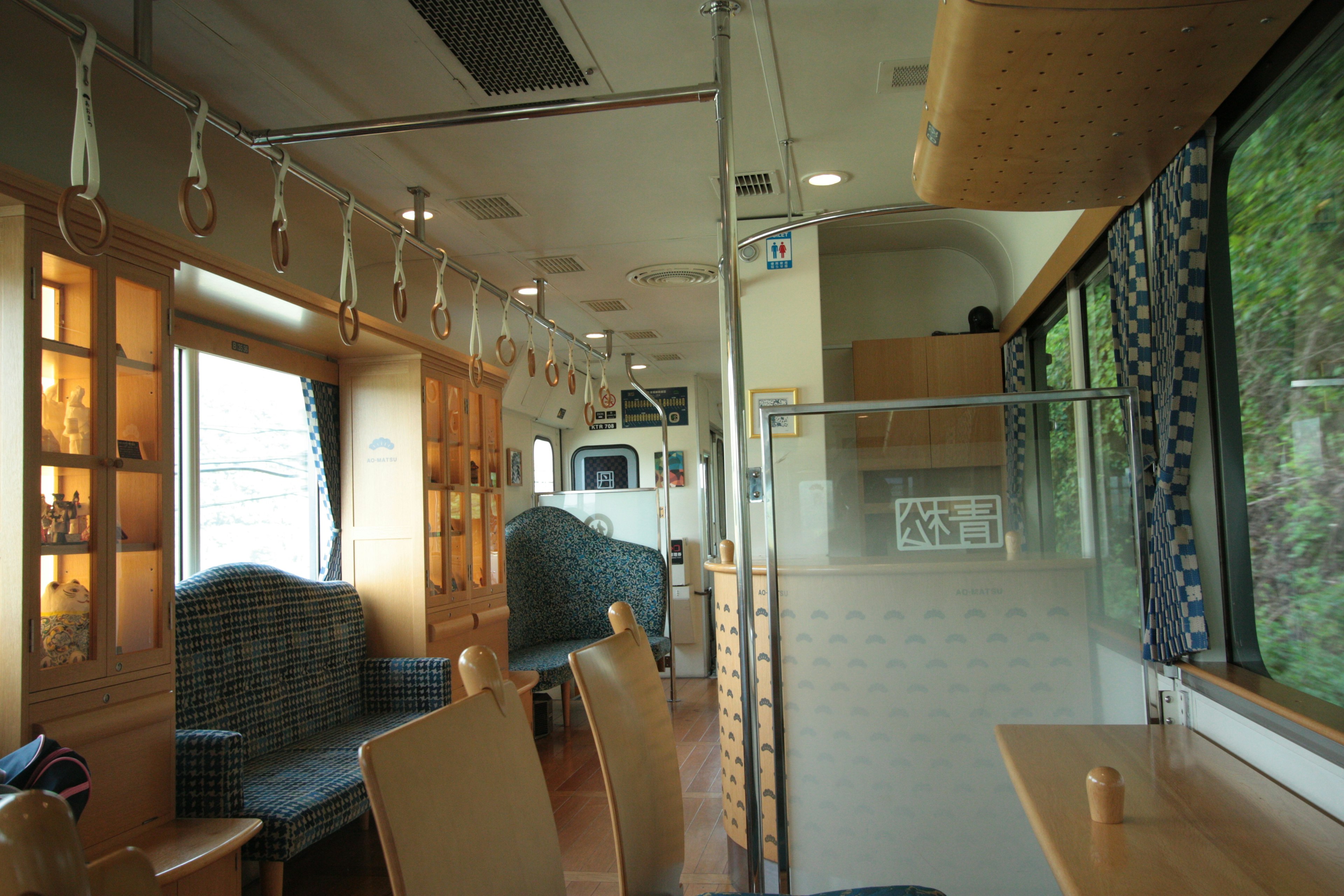 Modern train interior featuring wooden furniture and bright lighting