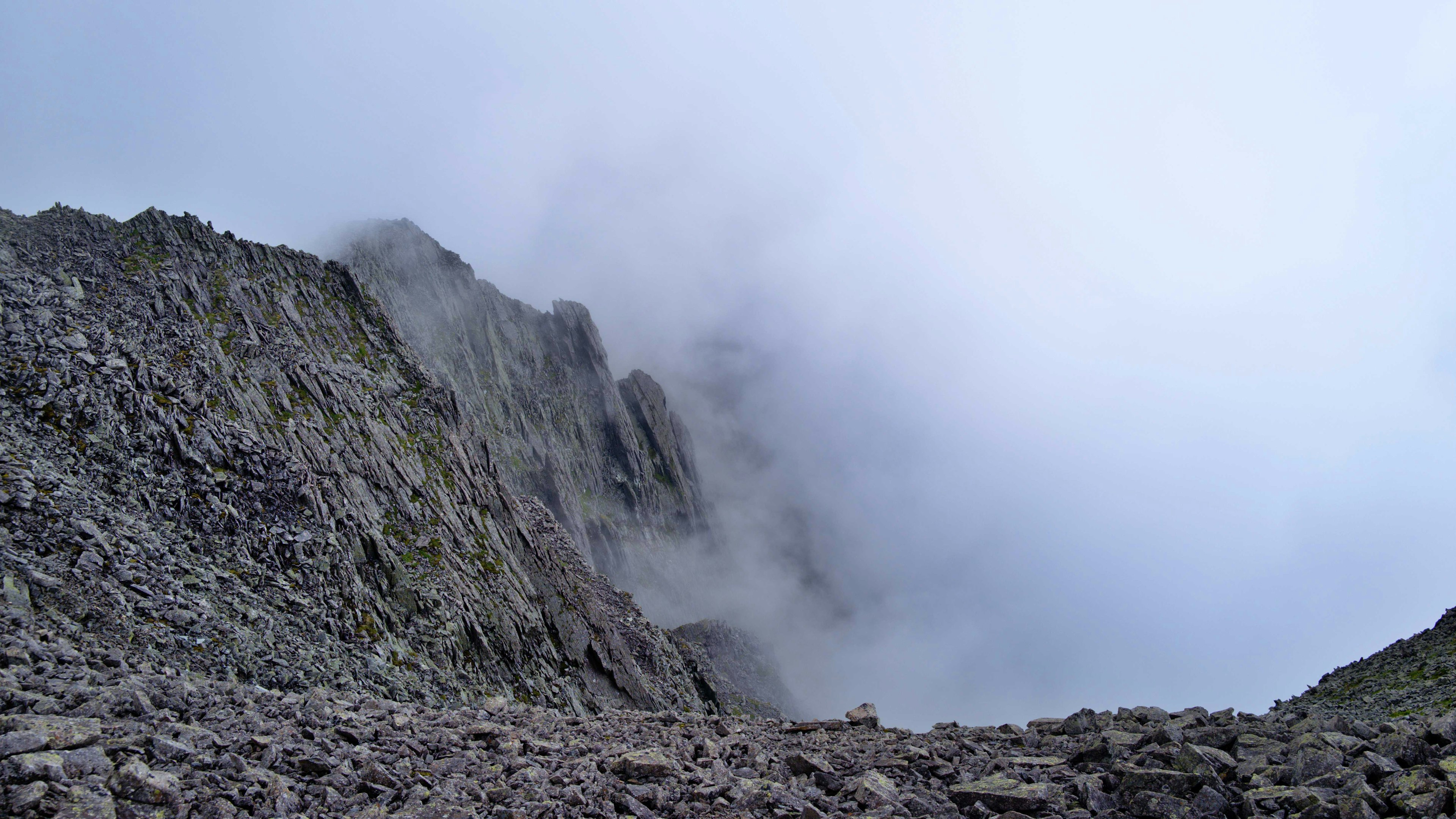 Paisaje rocoso con una montaña envuelta en nubes