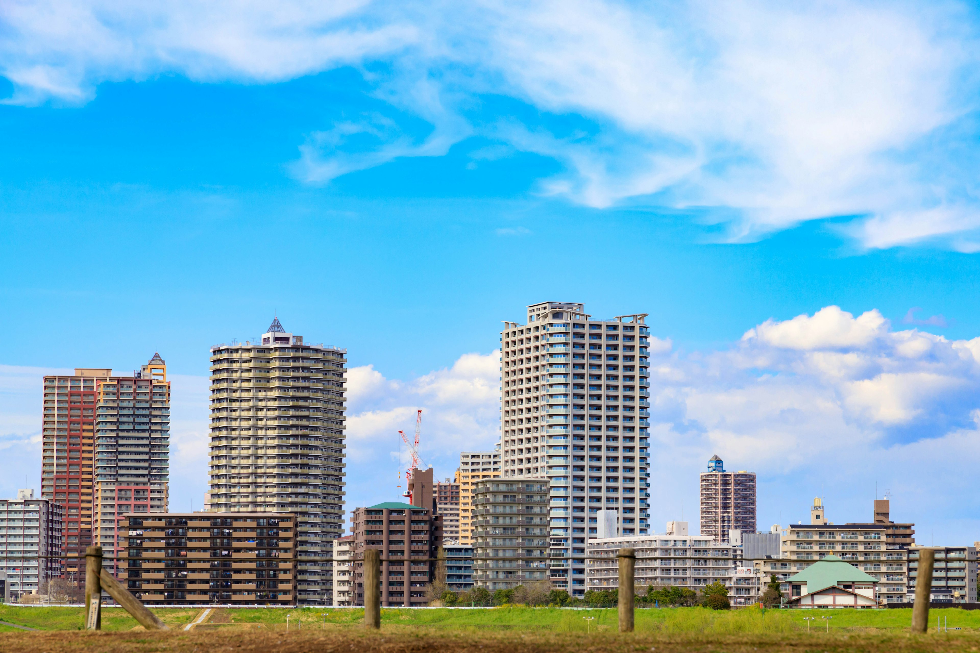 青い空の下に高層ビルが立ち並ぶ都市の風景