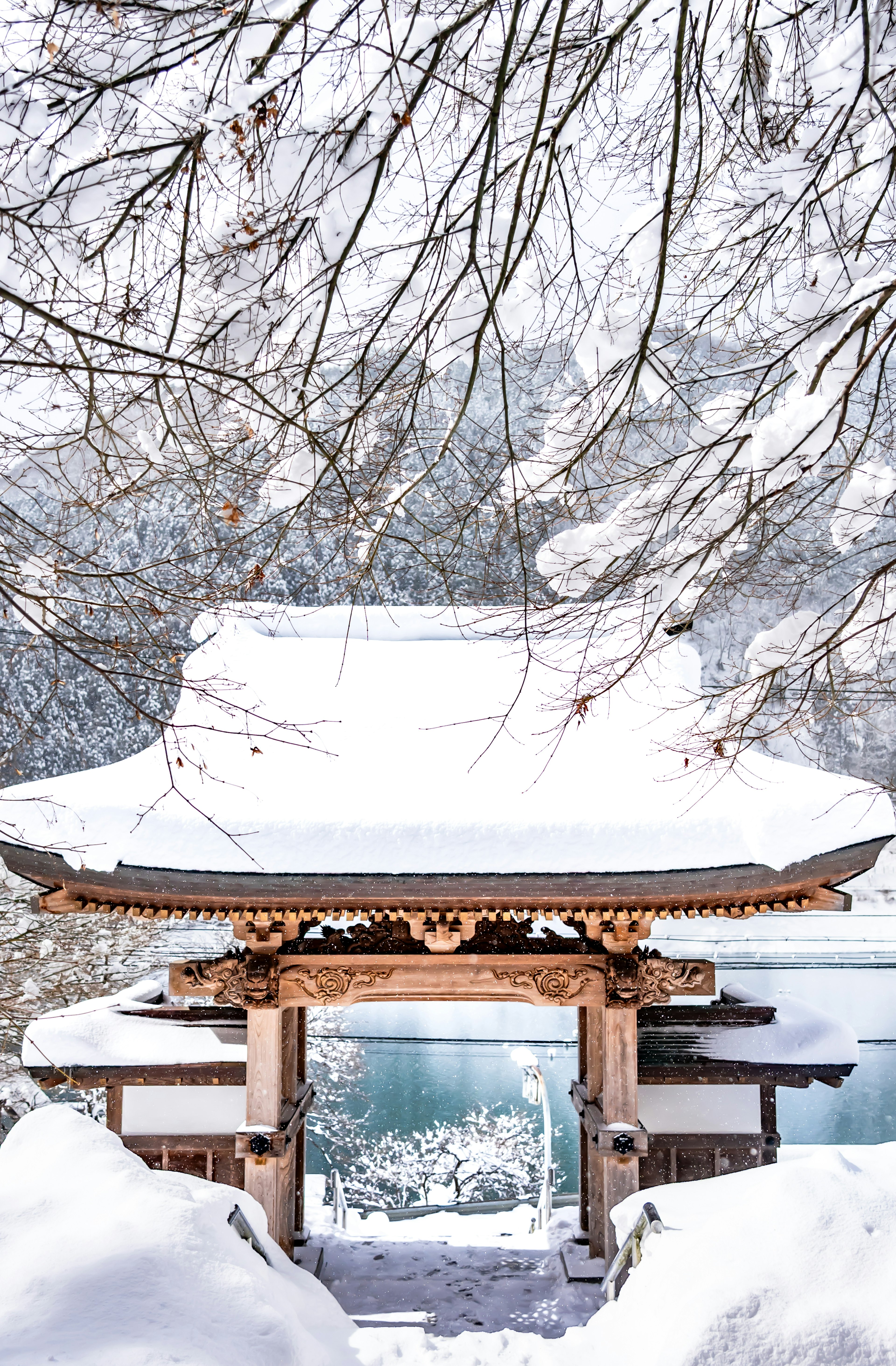 Snow-covered temple roof with a serene lake view