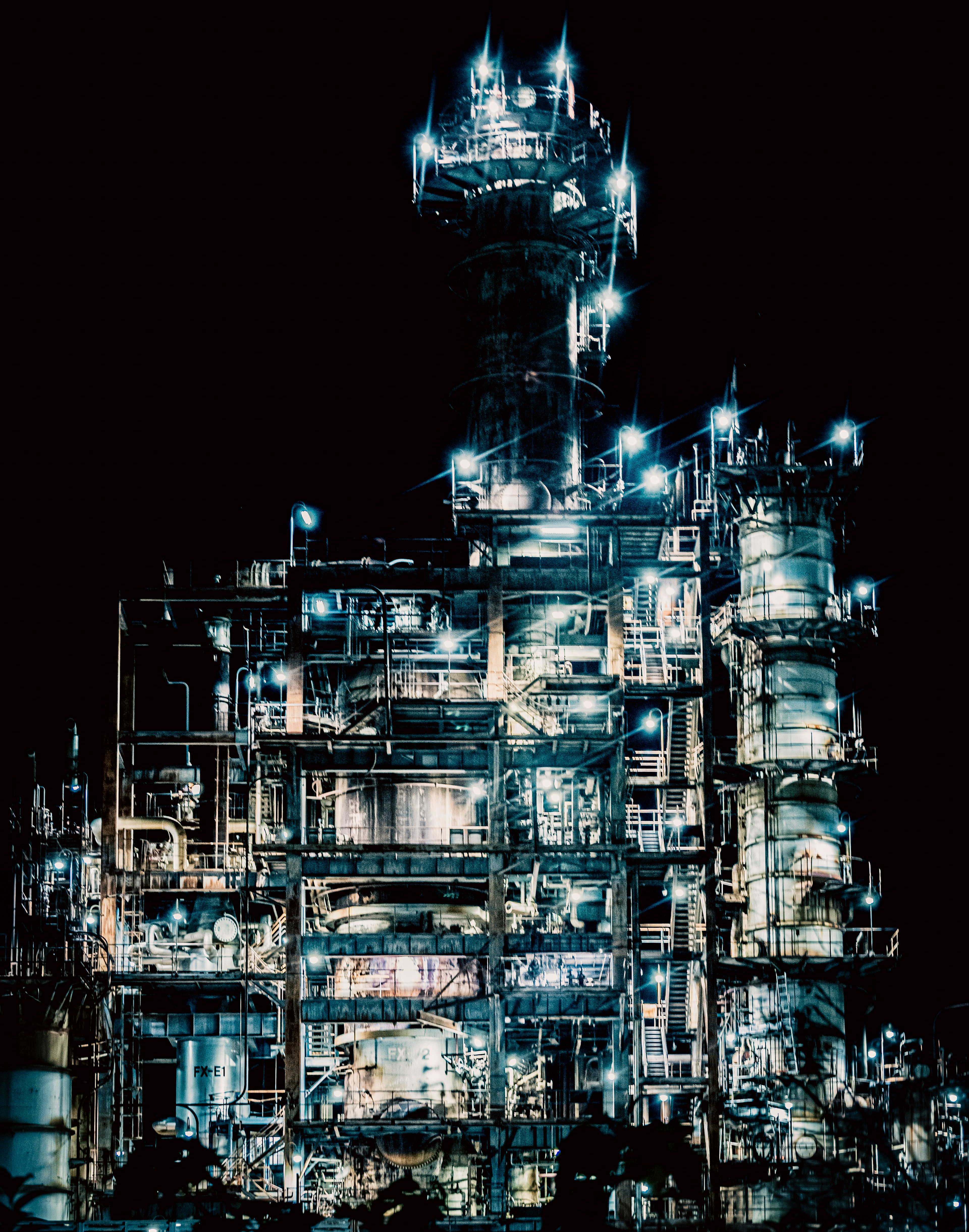 Illuminated industrial facility at night with intricate structures