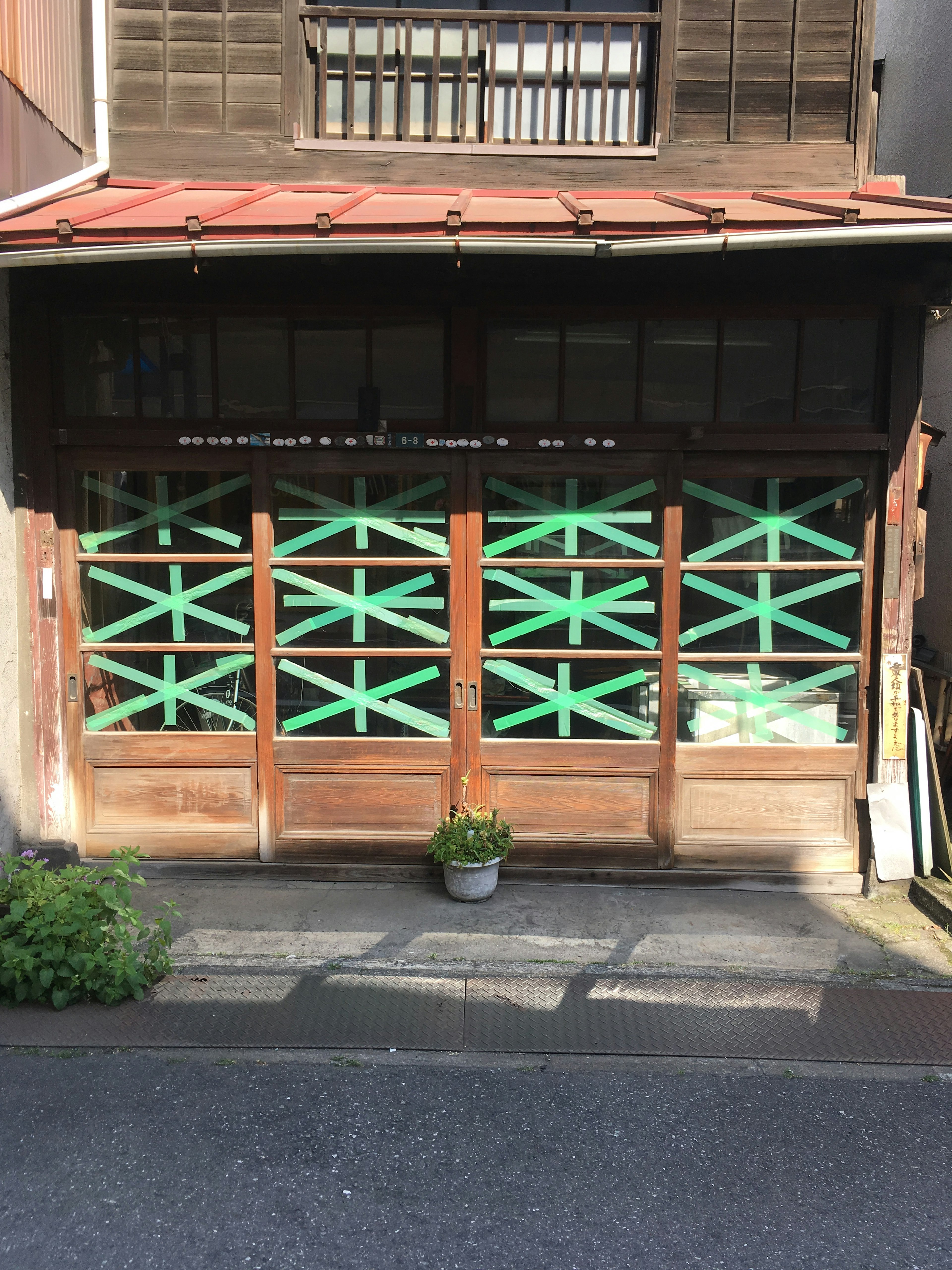 Rumah Jepang tua dengan pintu kayu yang memiliki pola silang hijau