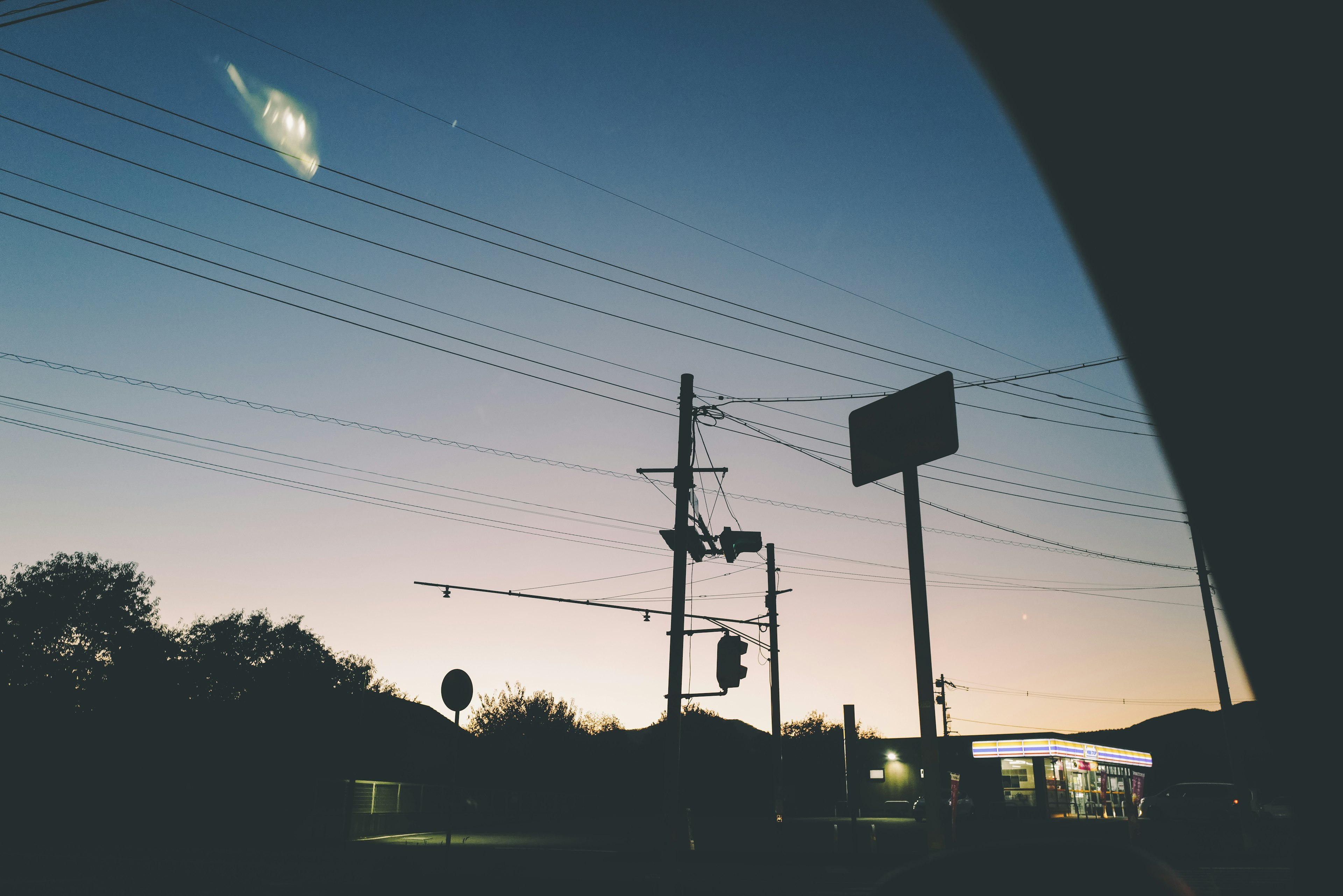 Silhouette of a city at dusk with power lines