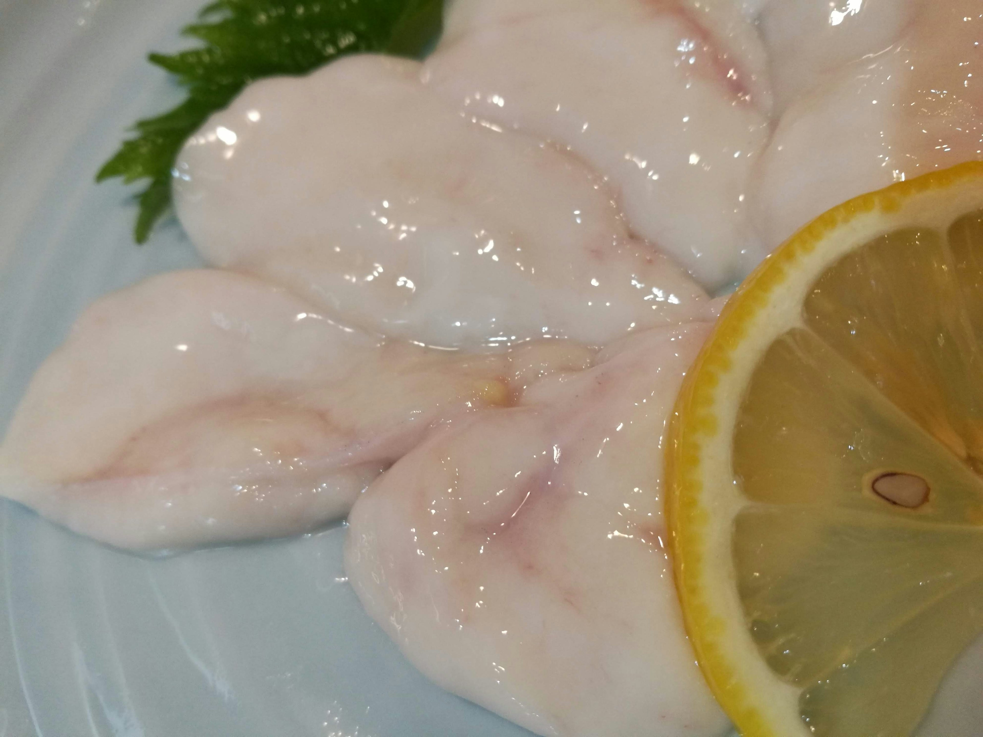 Sashimi de pescado en rodajas con una rodaja de limón