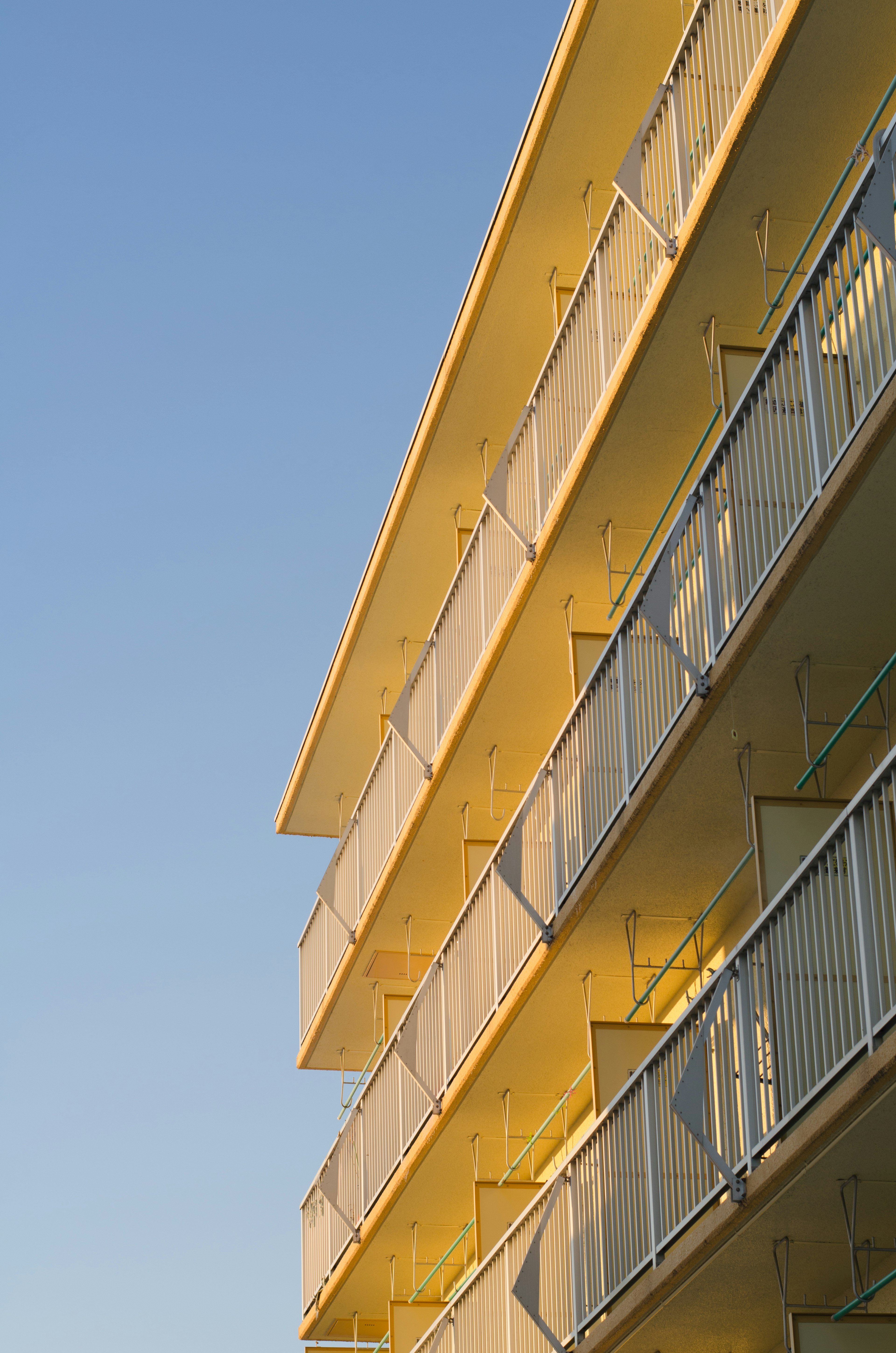 Yellow building balconies against a clear blue sky