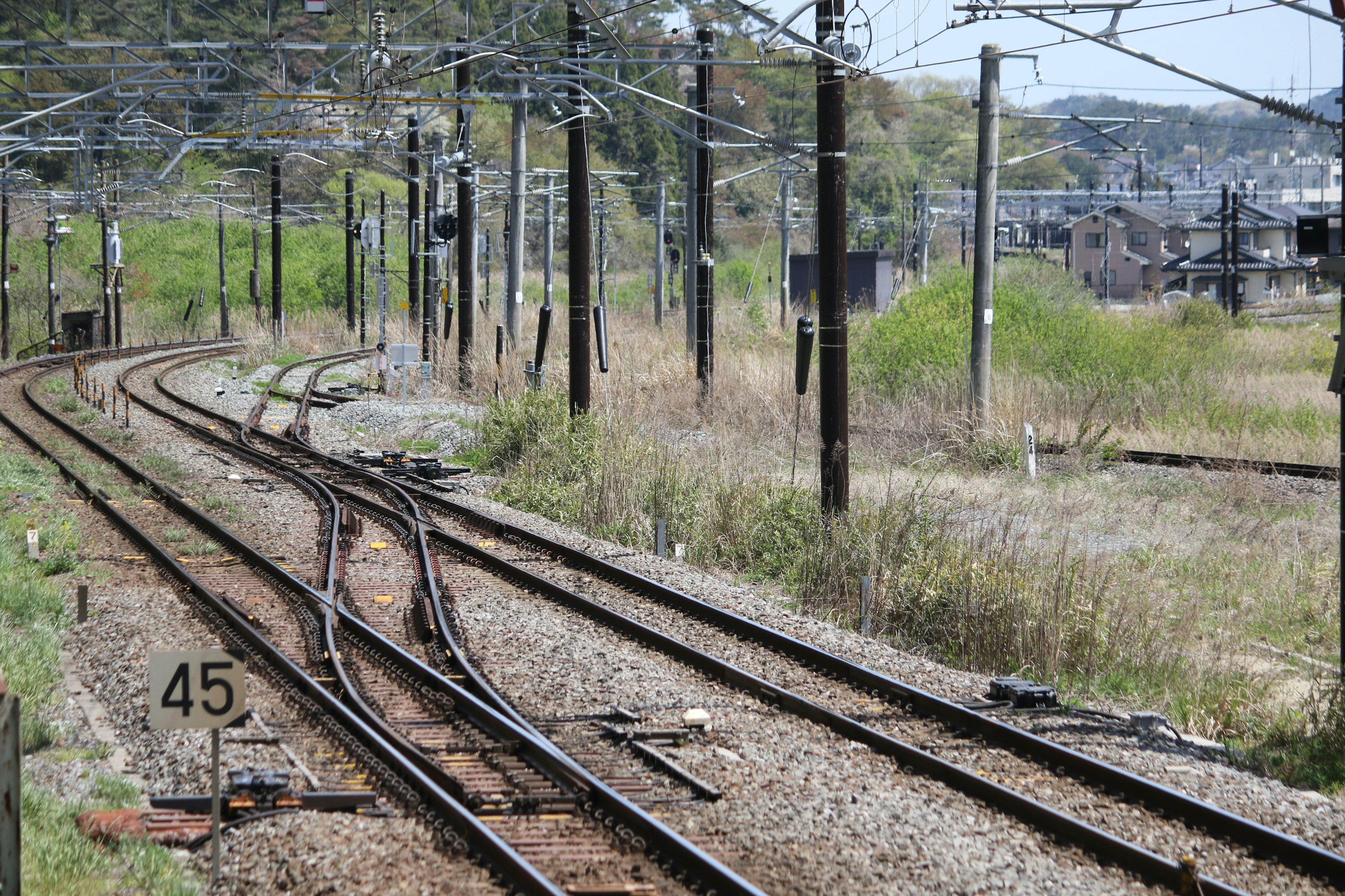 Escena de un cruce ferroviario con rieles curvos y hierba