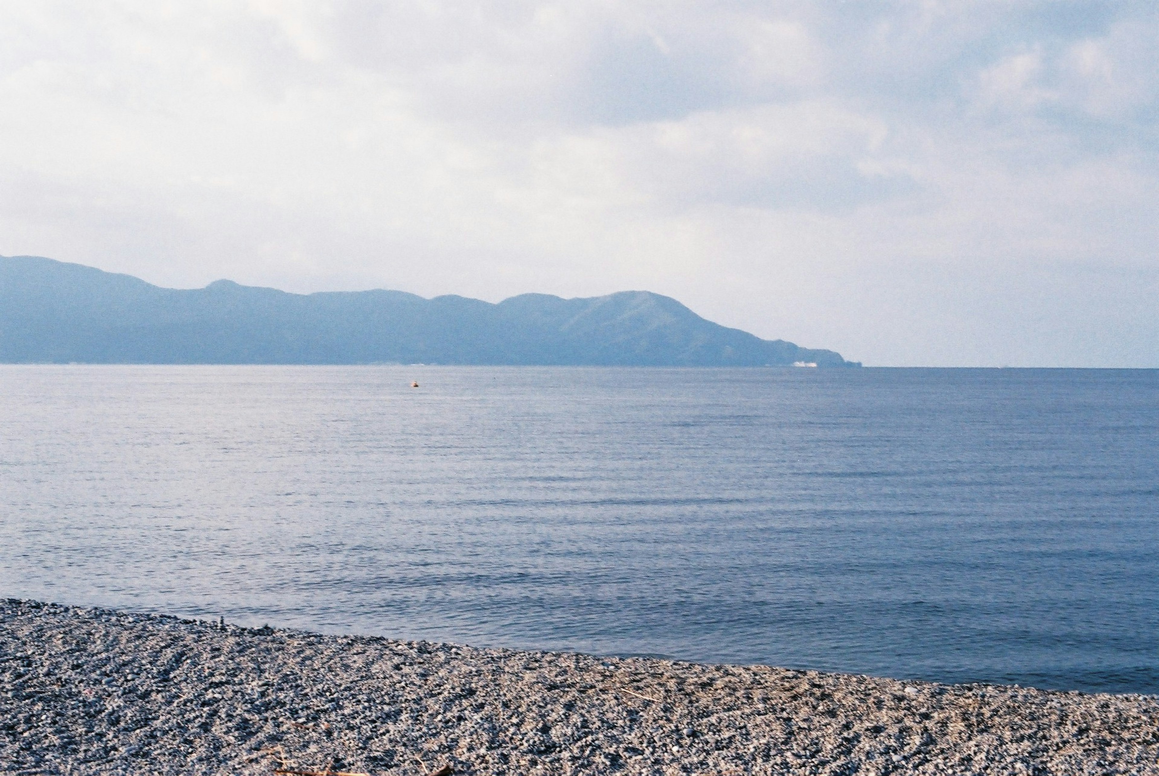 穏やかな海と石のビーチの風景