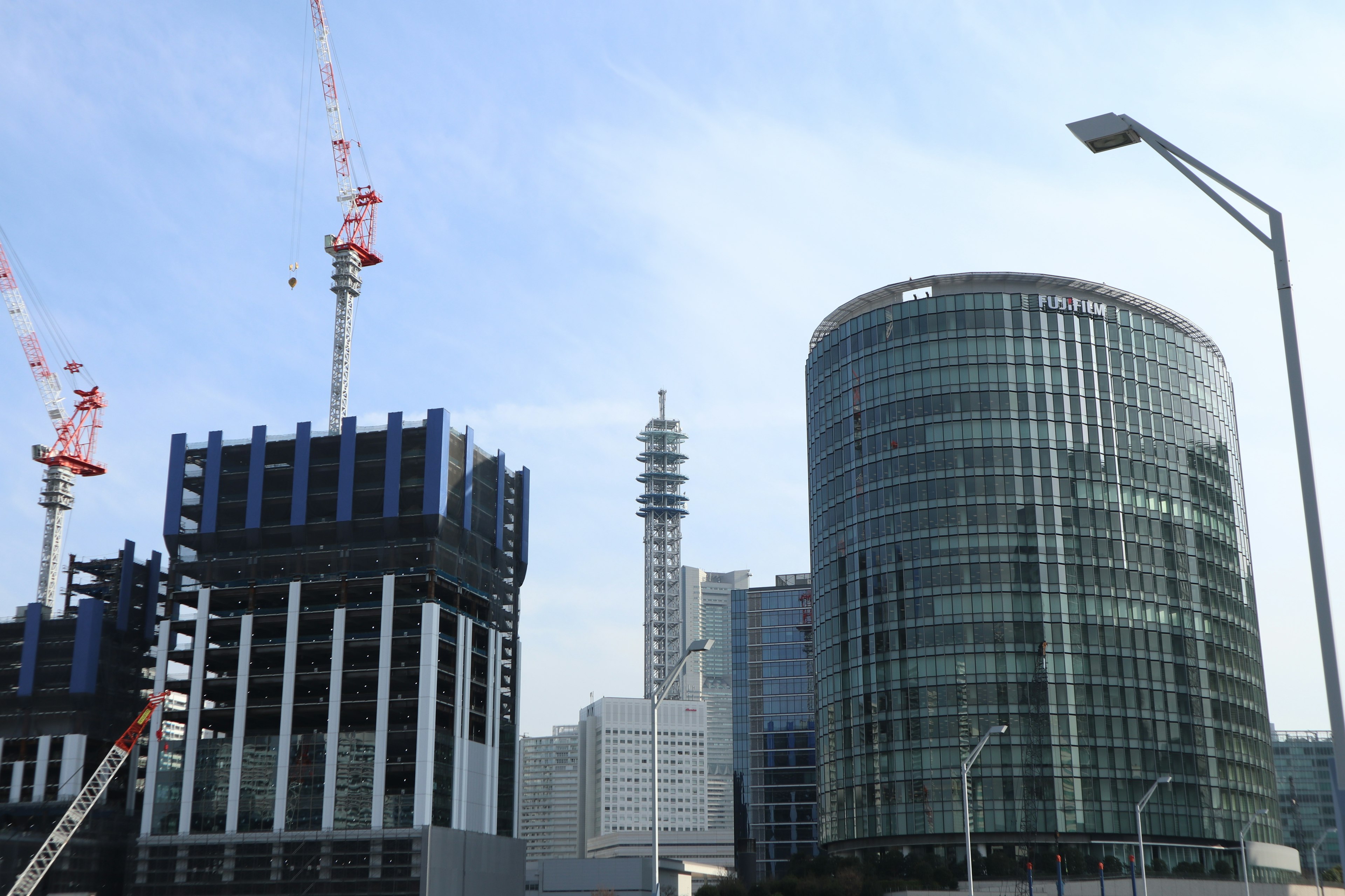 Urban skyline featuring under-construction buildings and a modern glass structure