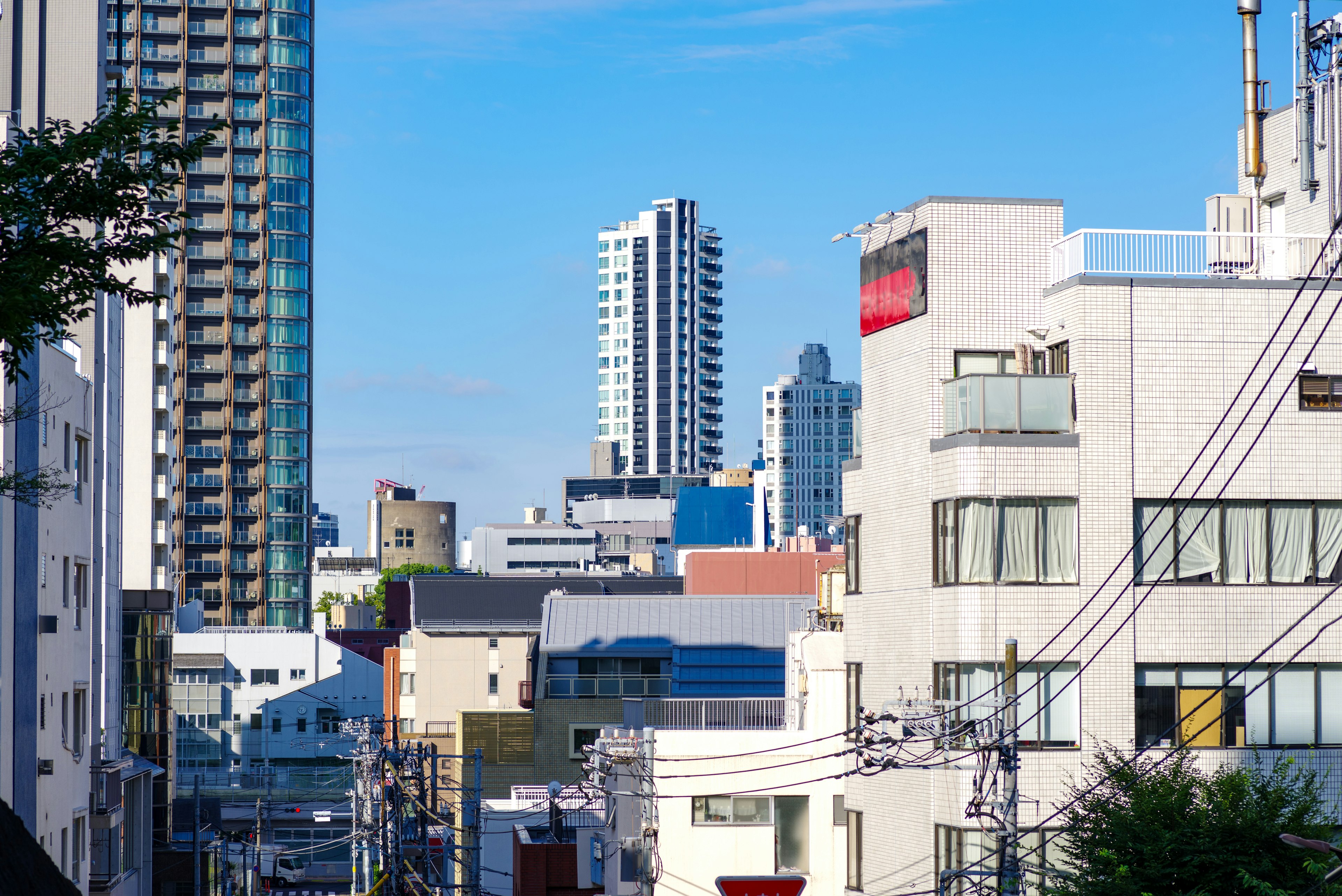 蓝天之下的城市风景，包含高层和低层建筑的混合