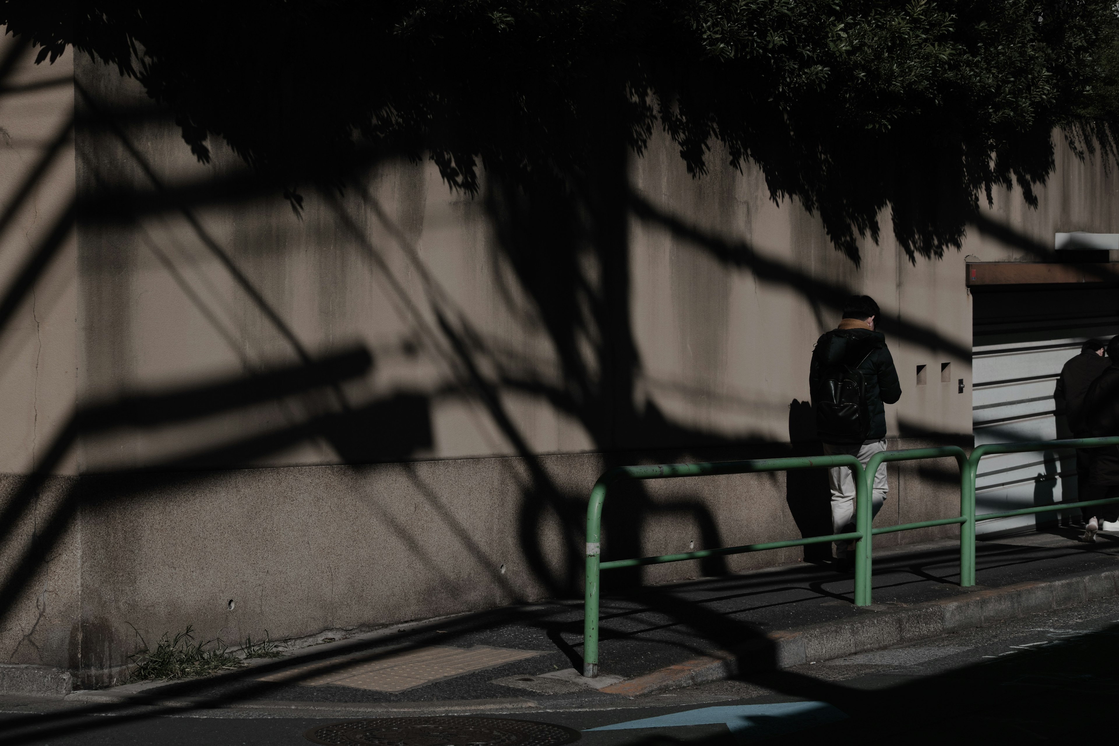 Scena urbana con ombre proiettate su un muro due persone in piedi