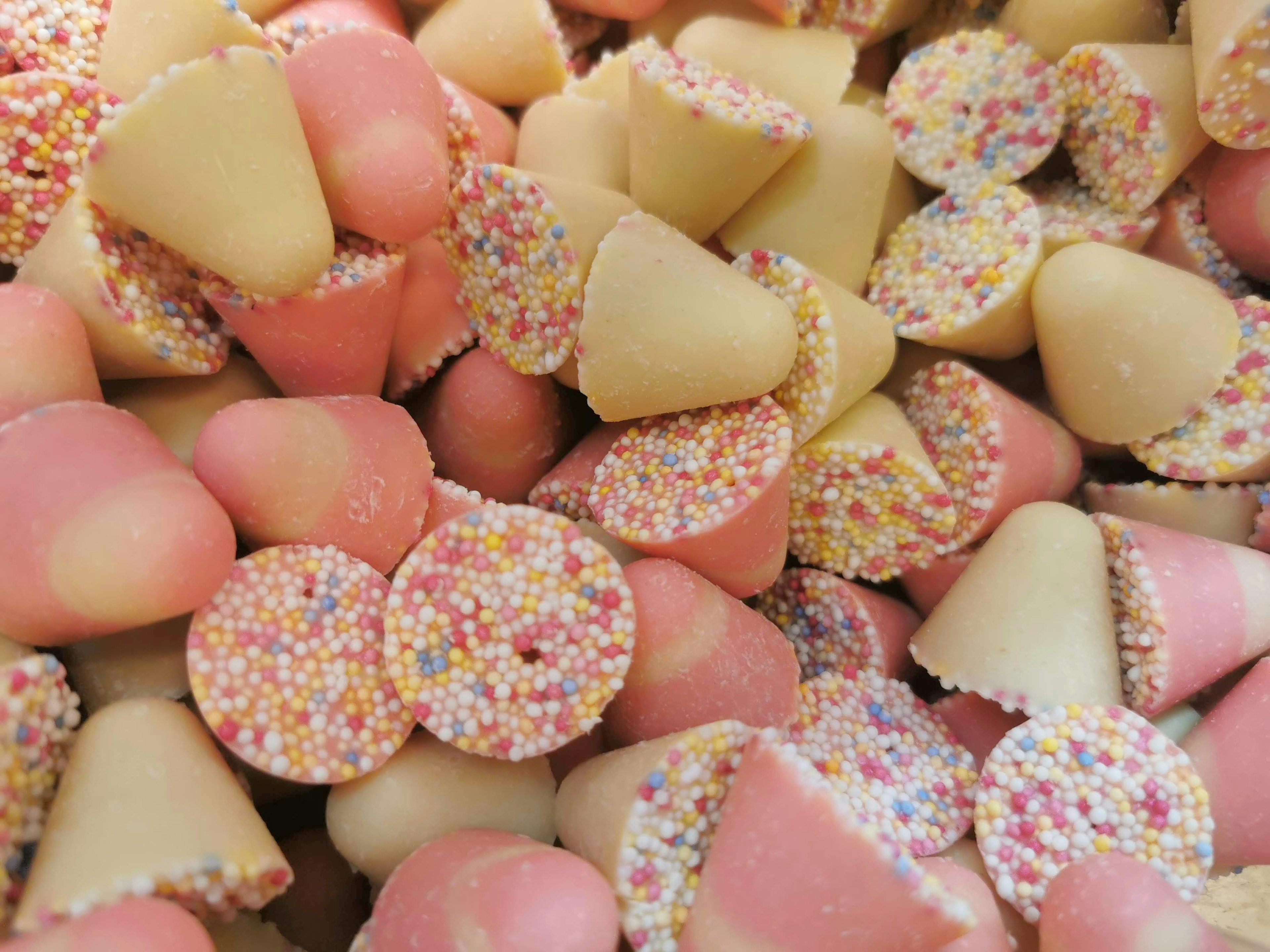 Colorful assortment of candies in pink and cream shapes