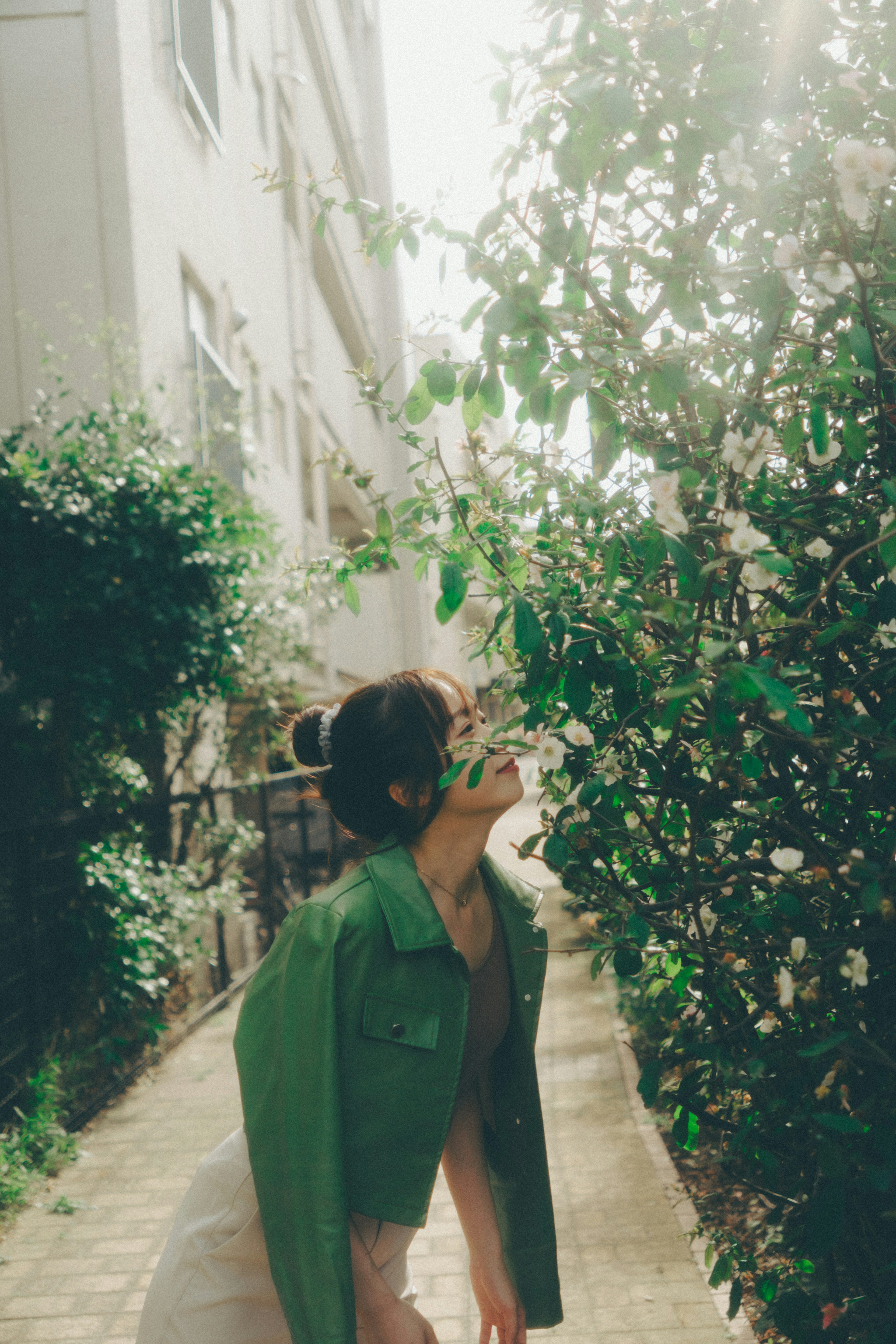 Une femme en veste verte se tenant près de la verdure