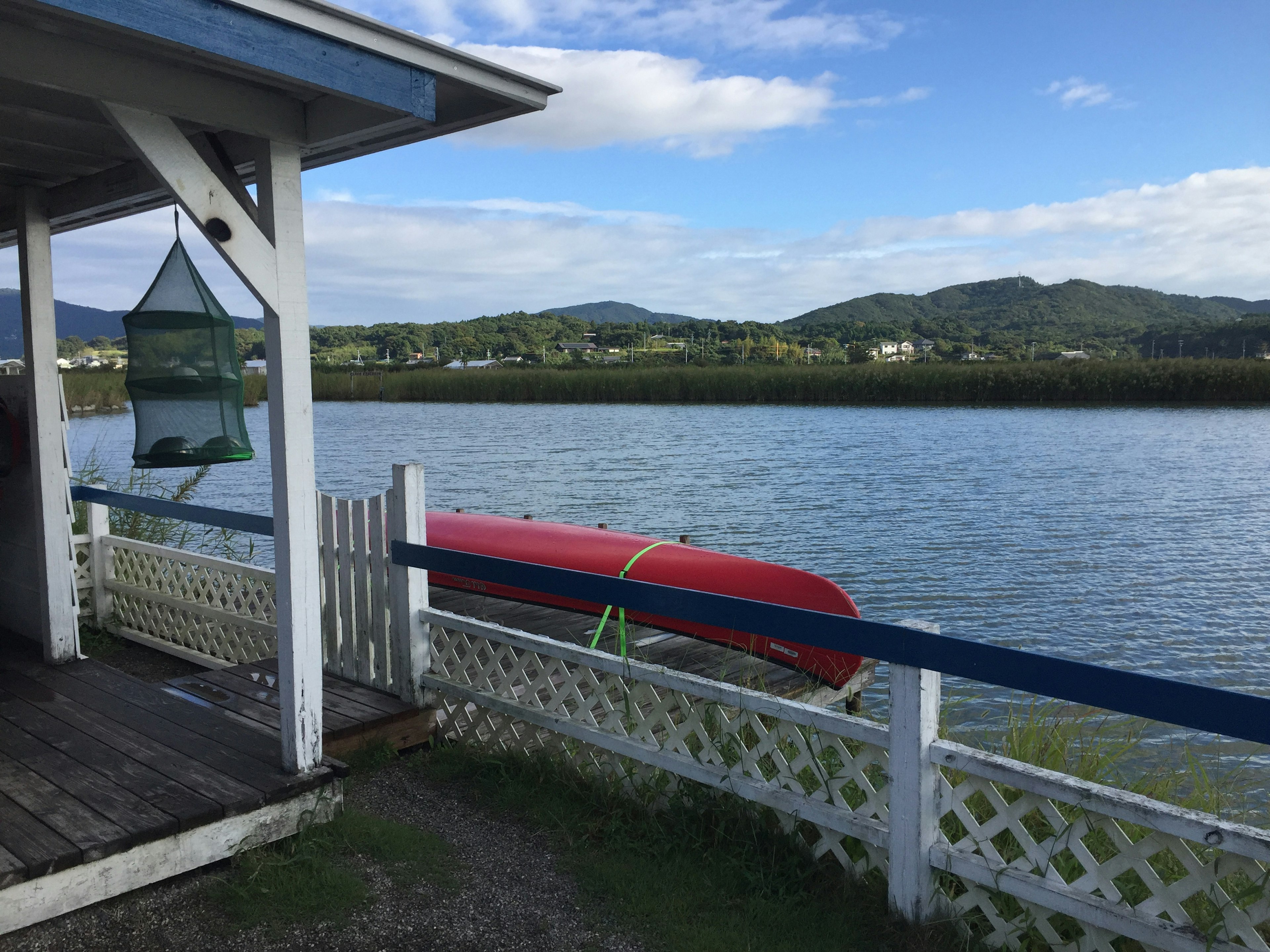 Malersicher Blick auf ein rotes Boot am Fluss mit Bergen im Hintergrund