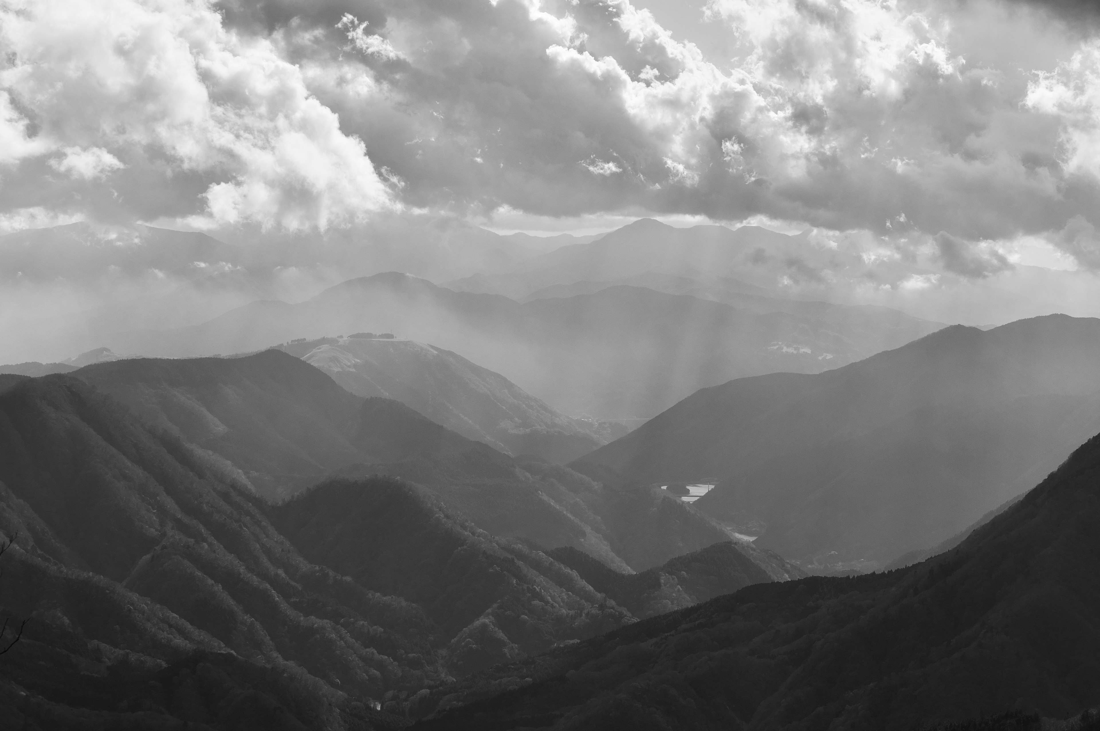 Paisaje en blanco y negro de montañas con nubes expansivas