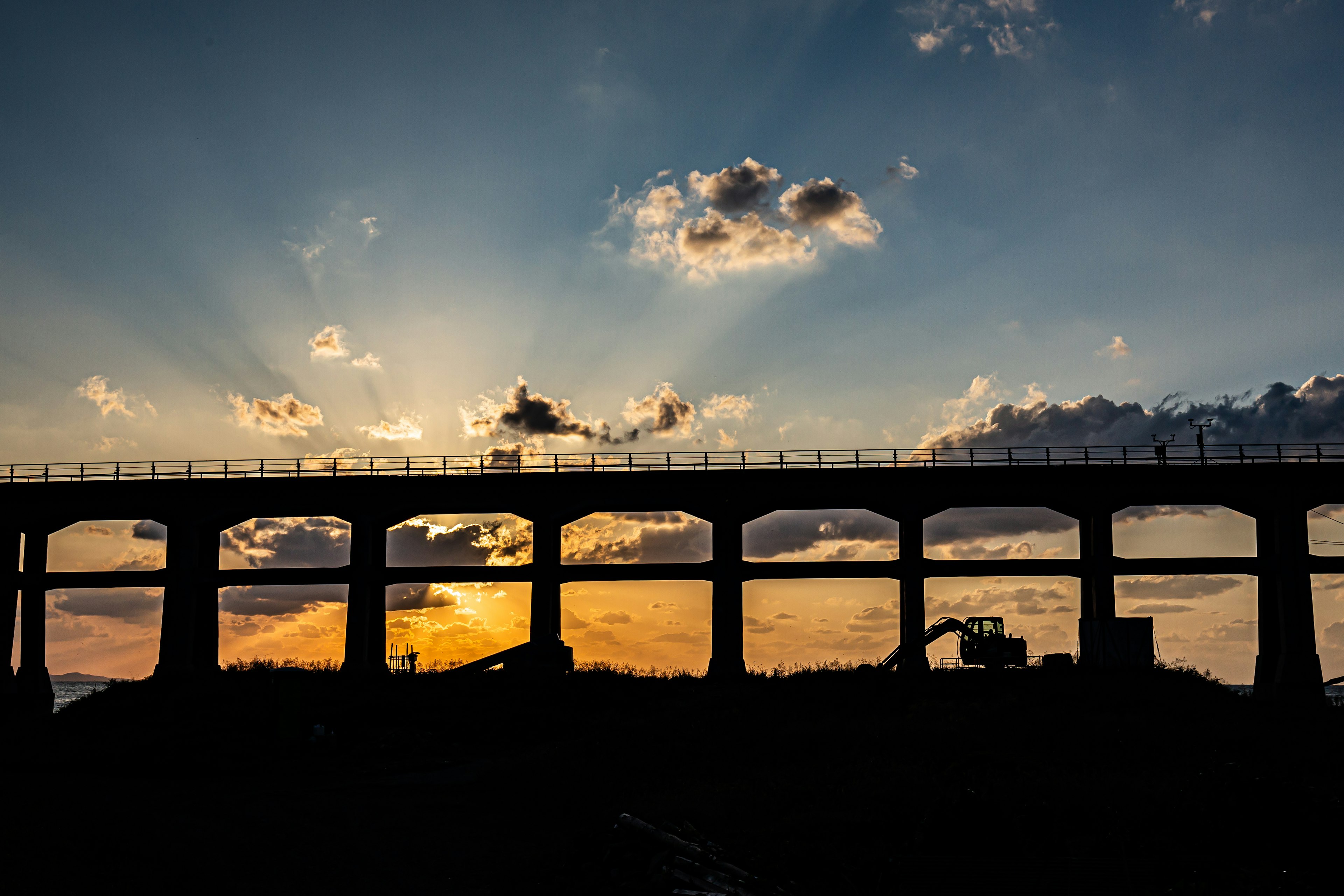 Silhouette d'un grand pont contre le coucher de soleil