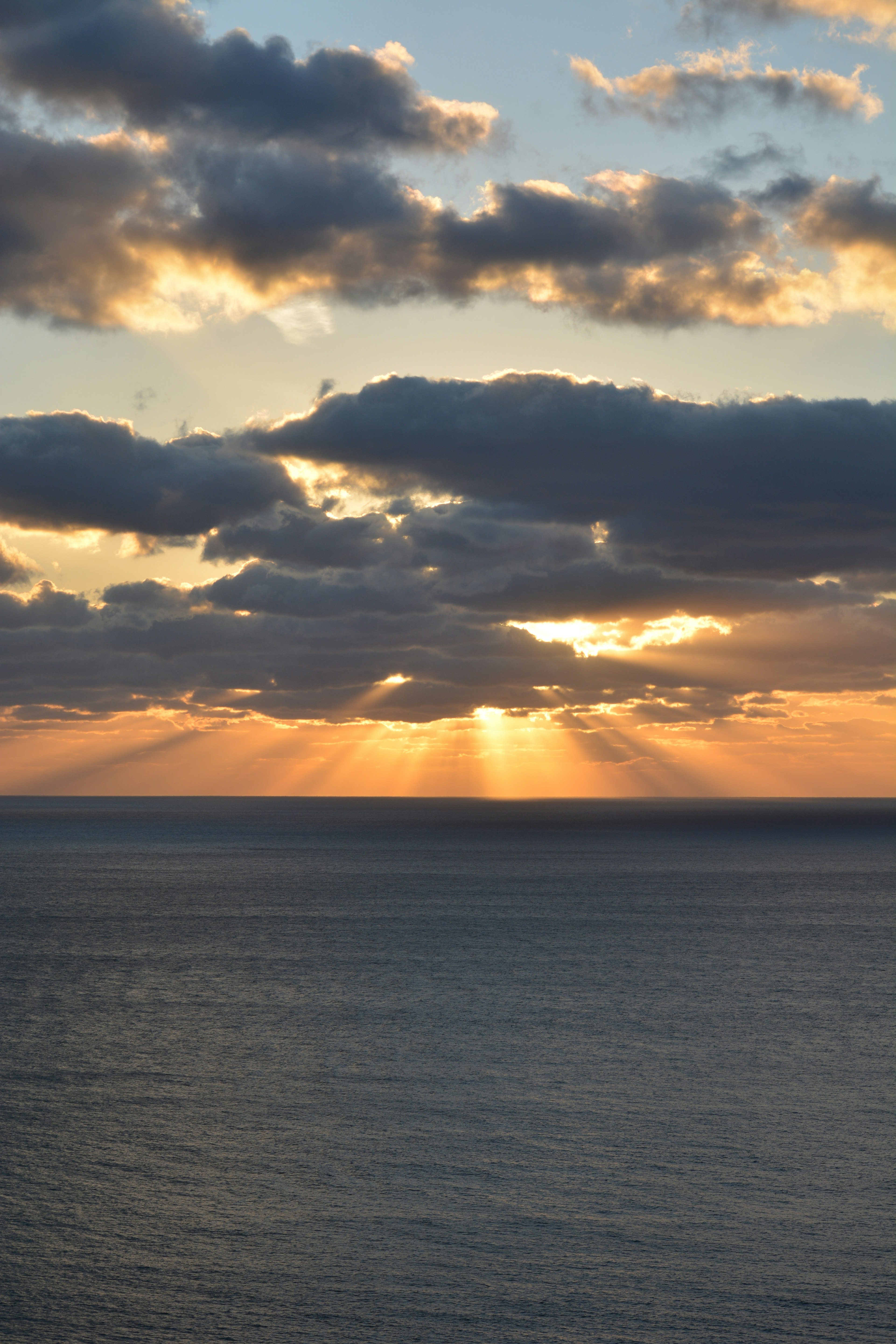 Magnifique coucher de soleil sur l'océan avec des rayons de lumière passant à travers les nuages