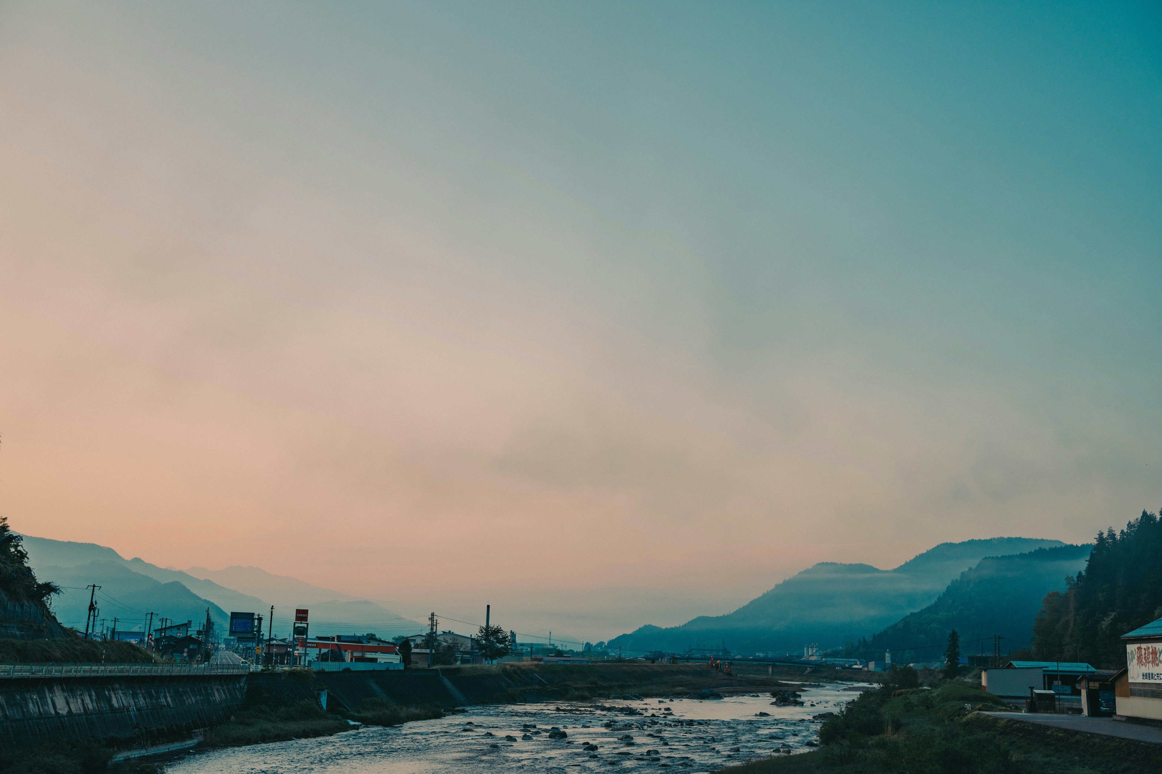 Landscape featuring a river and mountains under a blue sky