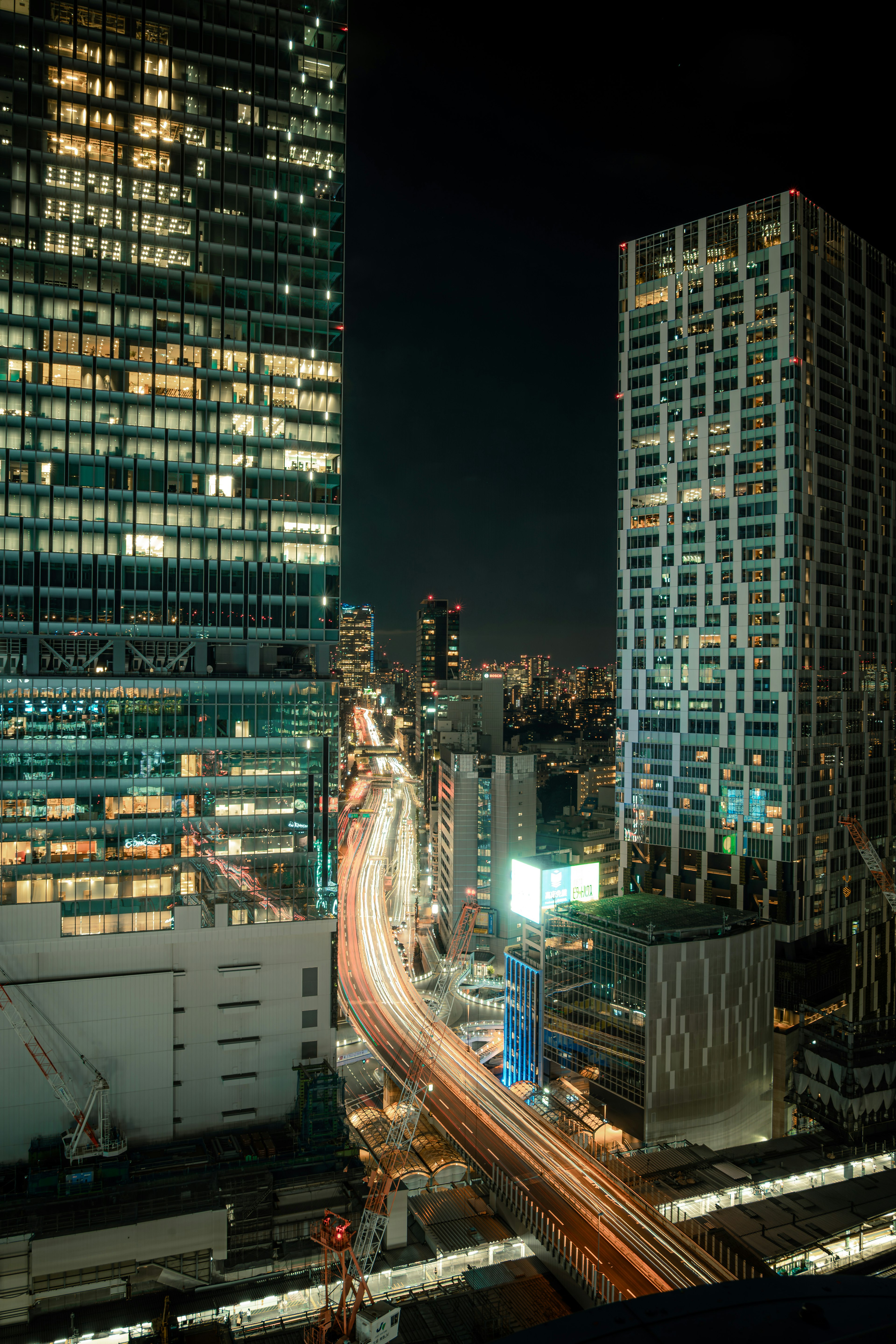 Vista notturna dei grattacieli di Tokyo con luci di auto in movimento