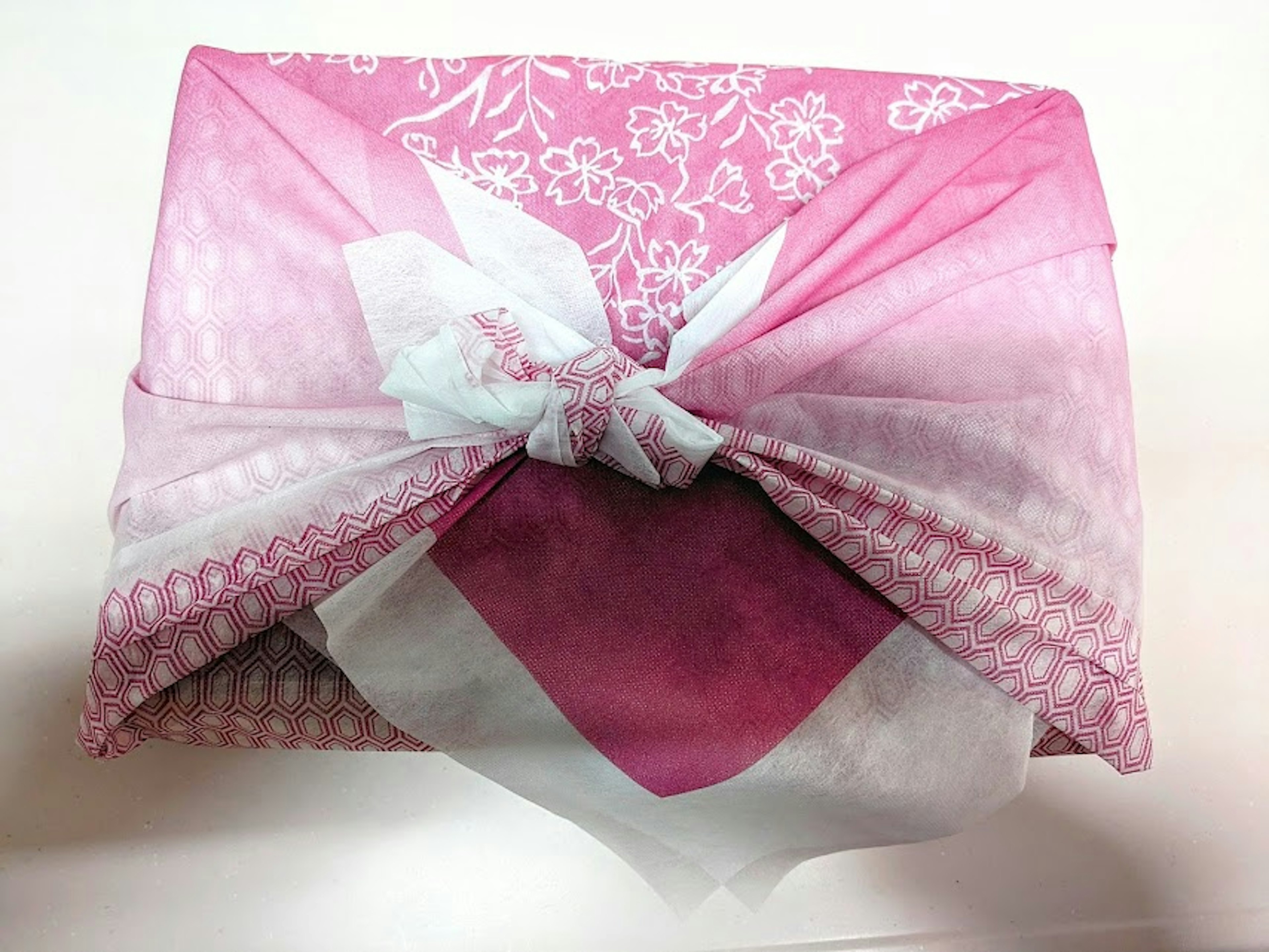 Gift wrapped in pink fabric with floral patterns