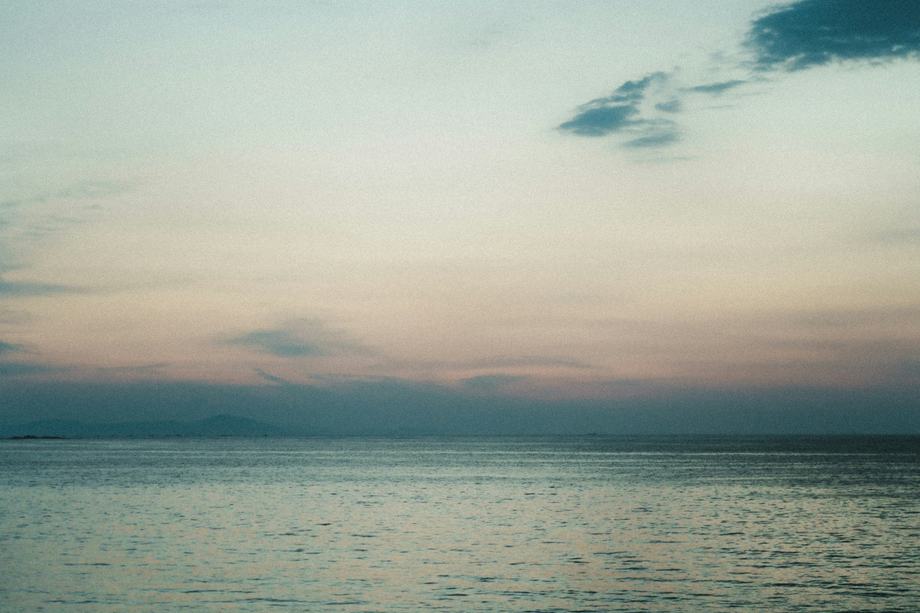 Ruhiges Meer mit sanftem Sonnenuntergangshimmel