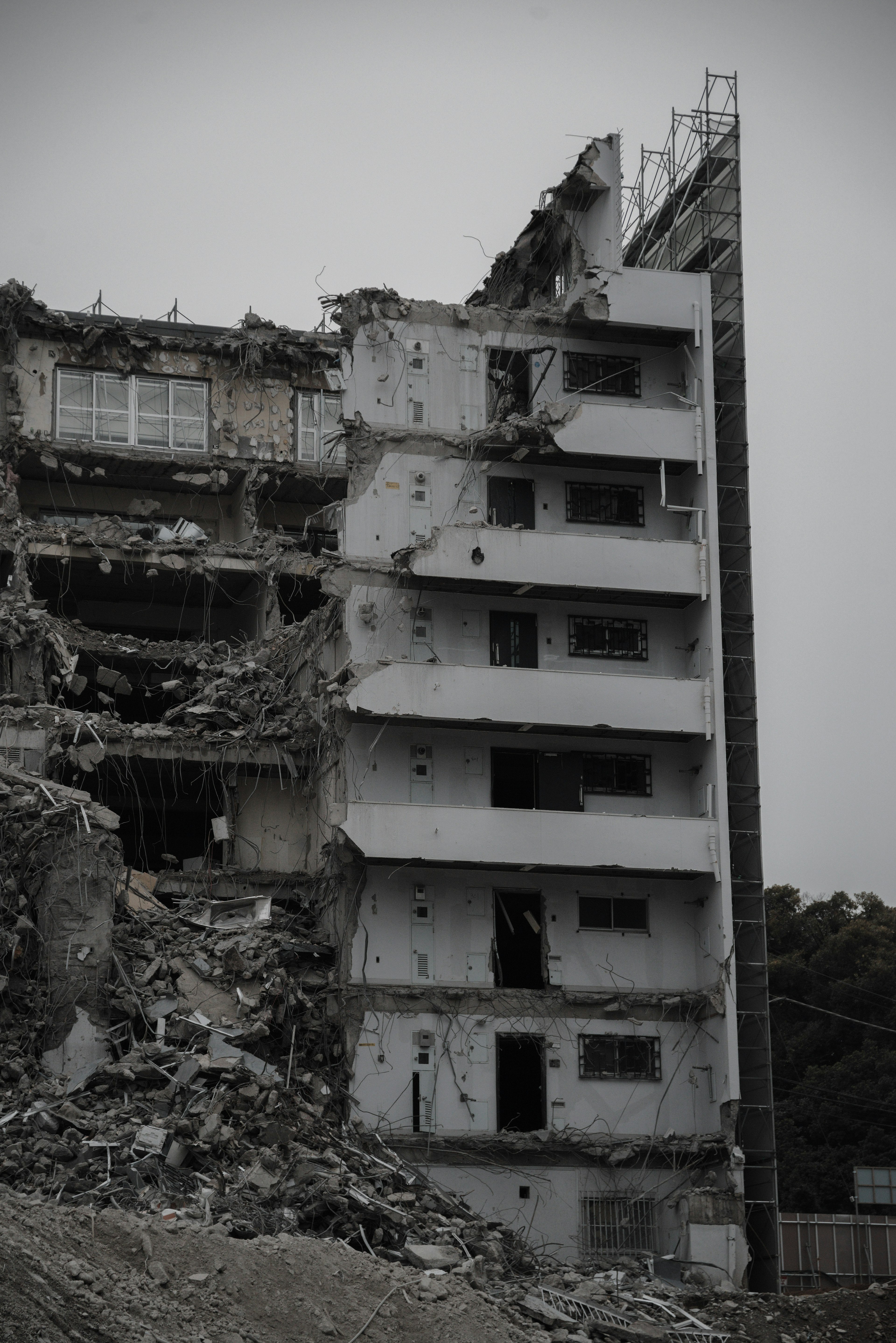 Side view of a damaged building with crumbling concrete structure