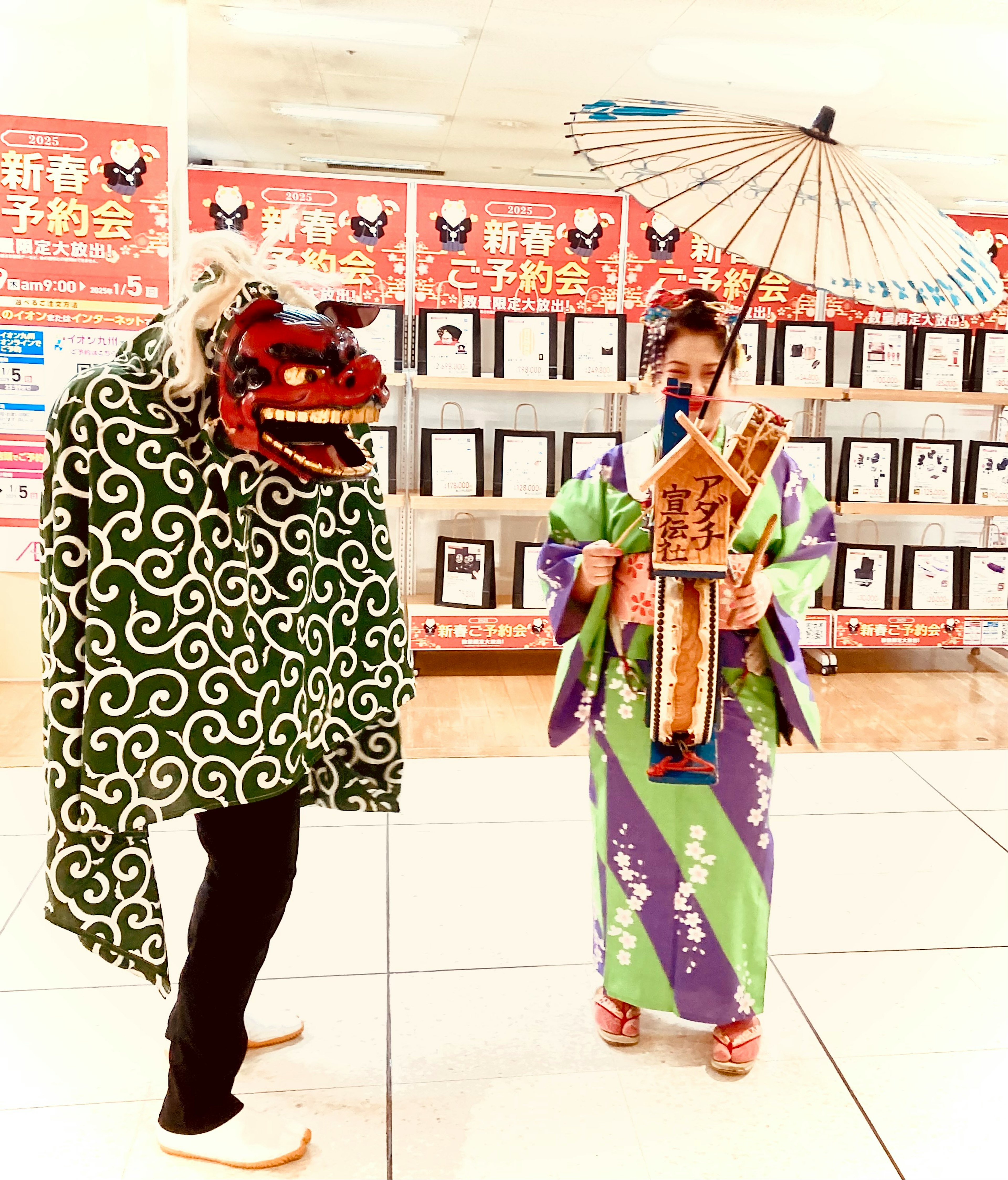 Một người trong trang phục múa sư tử xanh trắng và một phụ nữ trong kimono tím xanh cầm ô