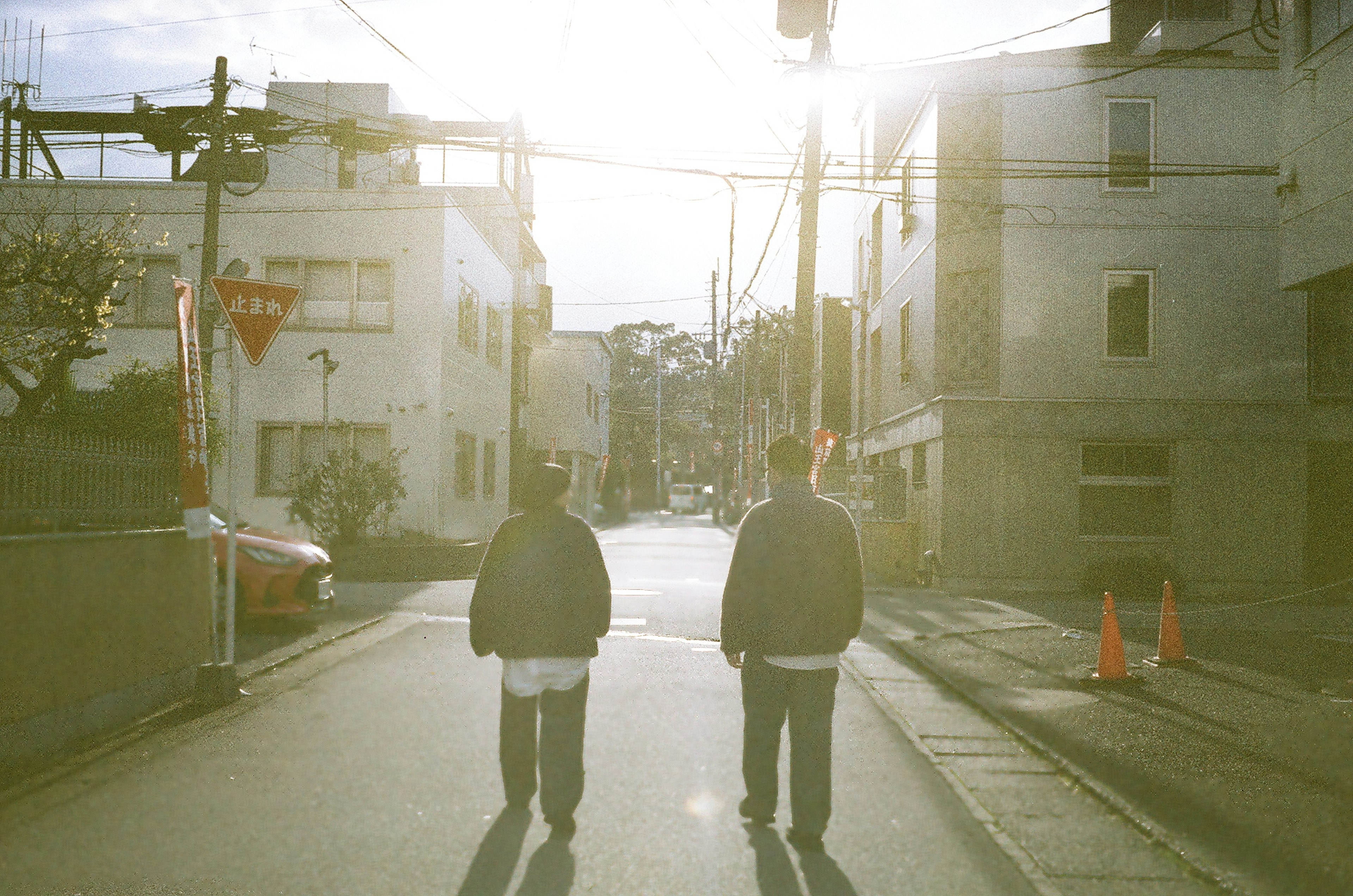 Dos hombres caminando por una calle iluminada