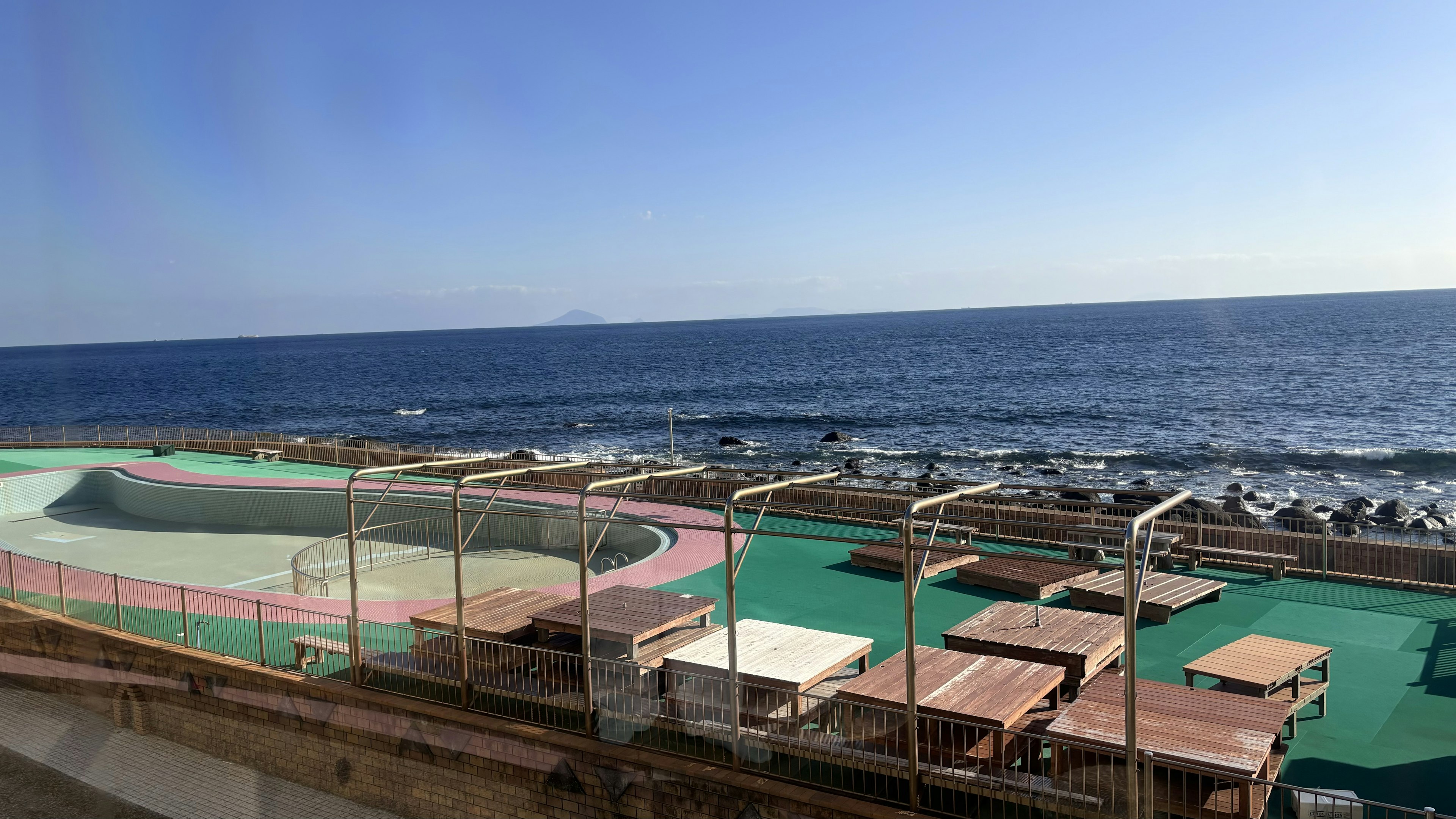 Seaside view with playground area and wooden tables