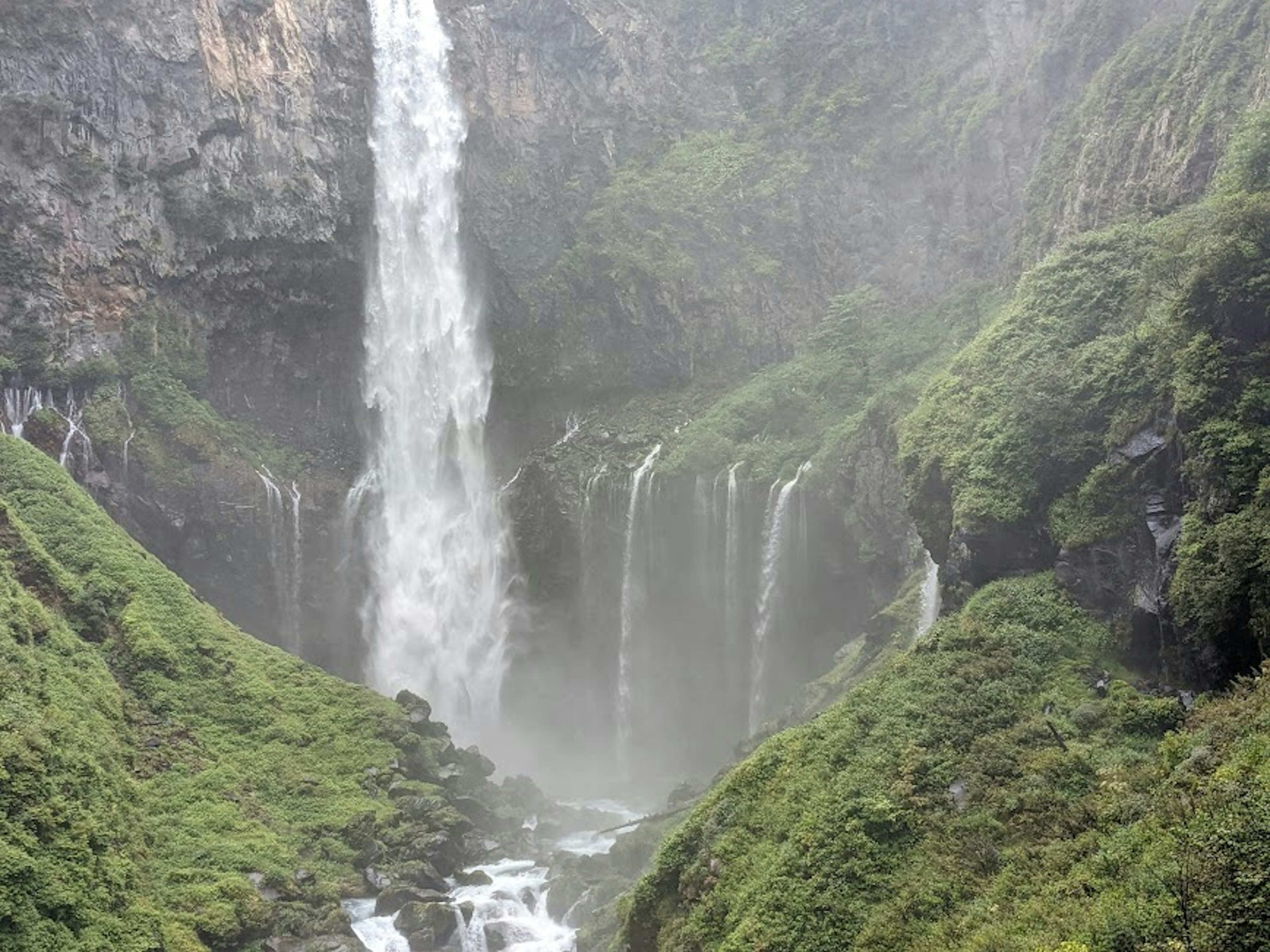 Maestosa cascata circondata da montagne verdi