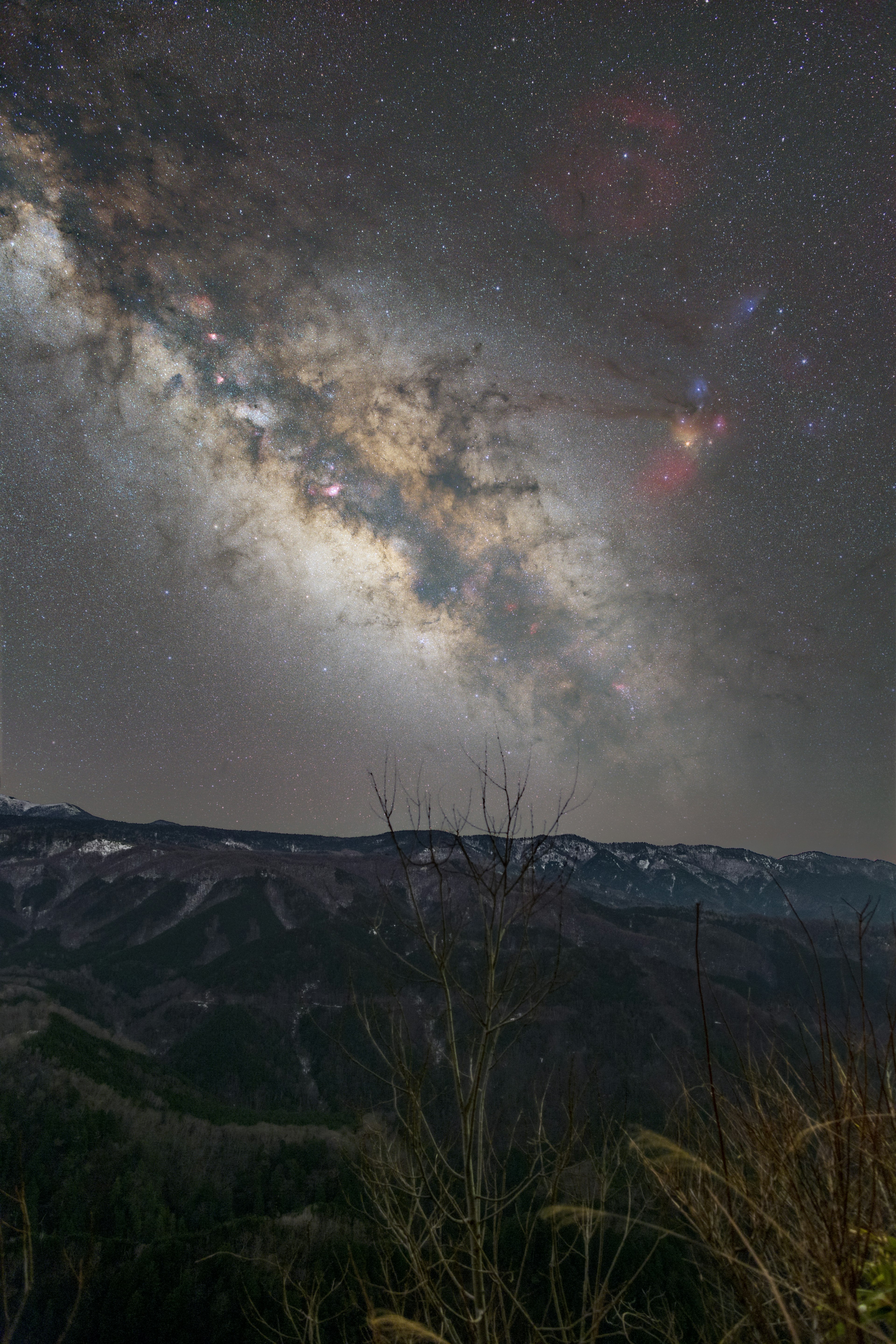 星空の下に広がる銀河系の美しい景色と山々