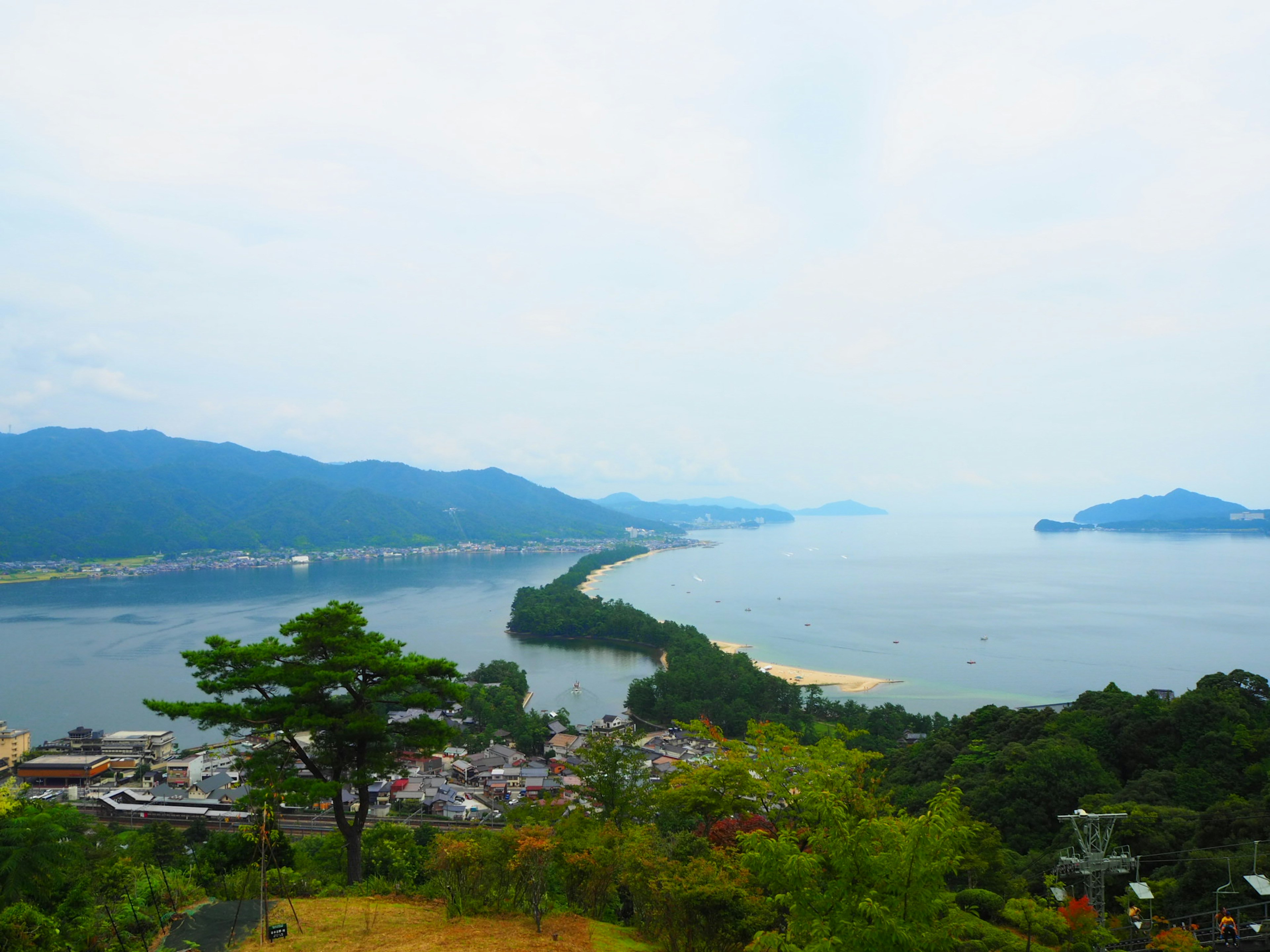 Panoramablick auf ein Küstendorf mit Bergen im Hintergrund