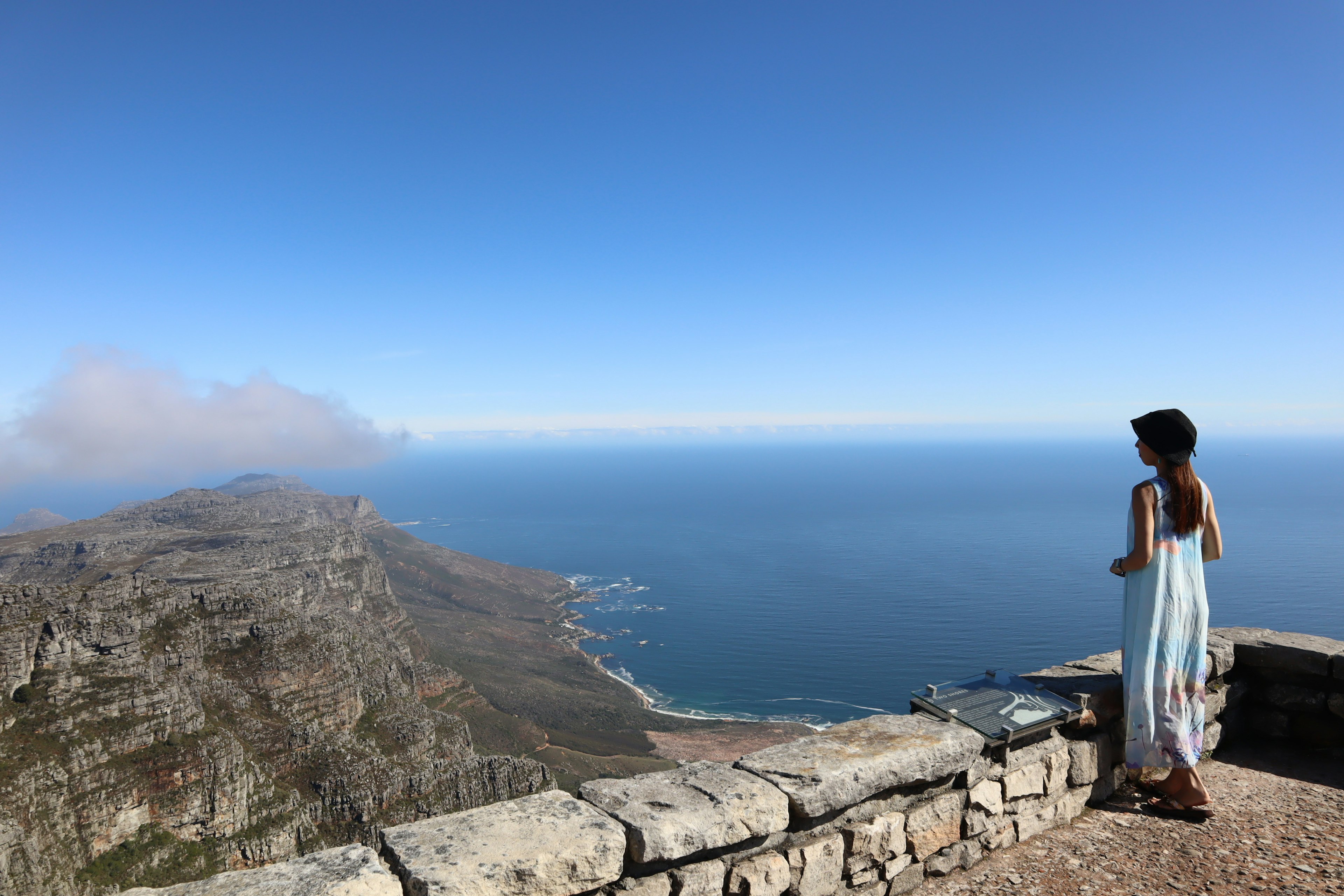 Una donna che osserva una bellissima vista sull'oceano e la montagna